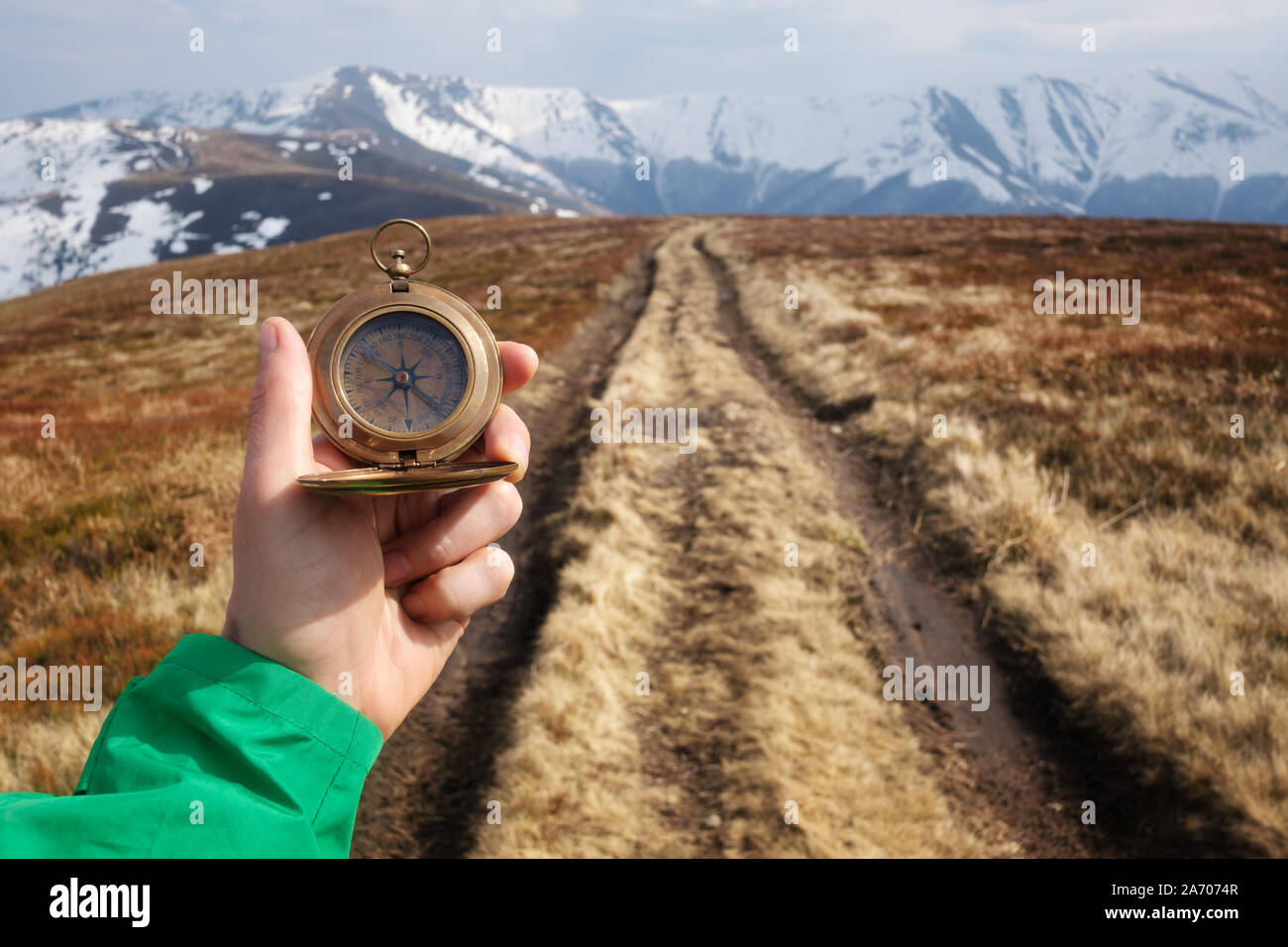 Man with retro compass in hand in high mountains. Travel concept. Landscape photography Stock Photo