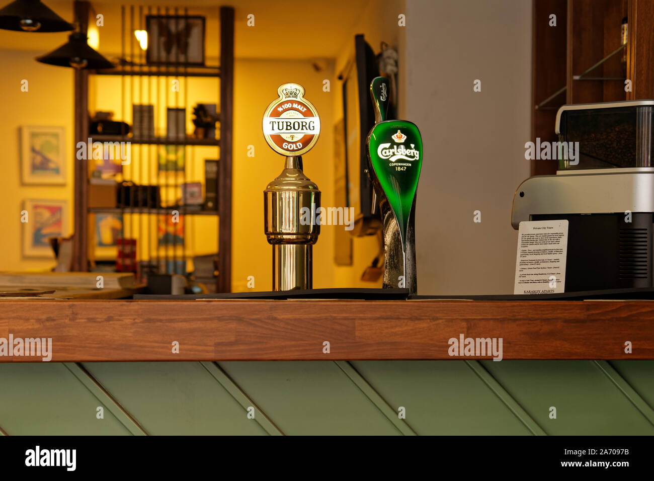 Beer pulls of famous beer brands Tuborg and Carslberg on a restaurant bar counter. Stock Photo