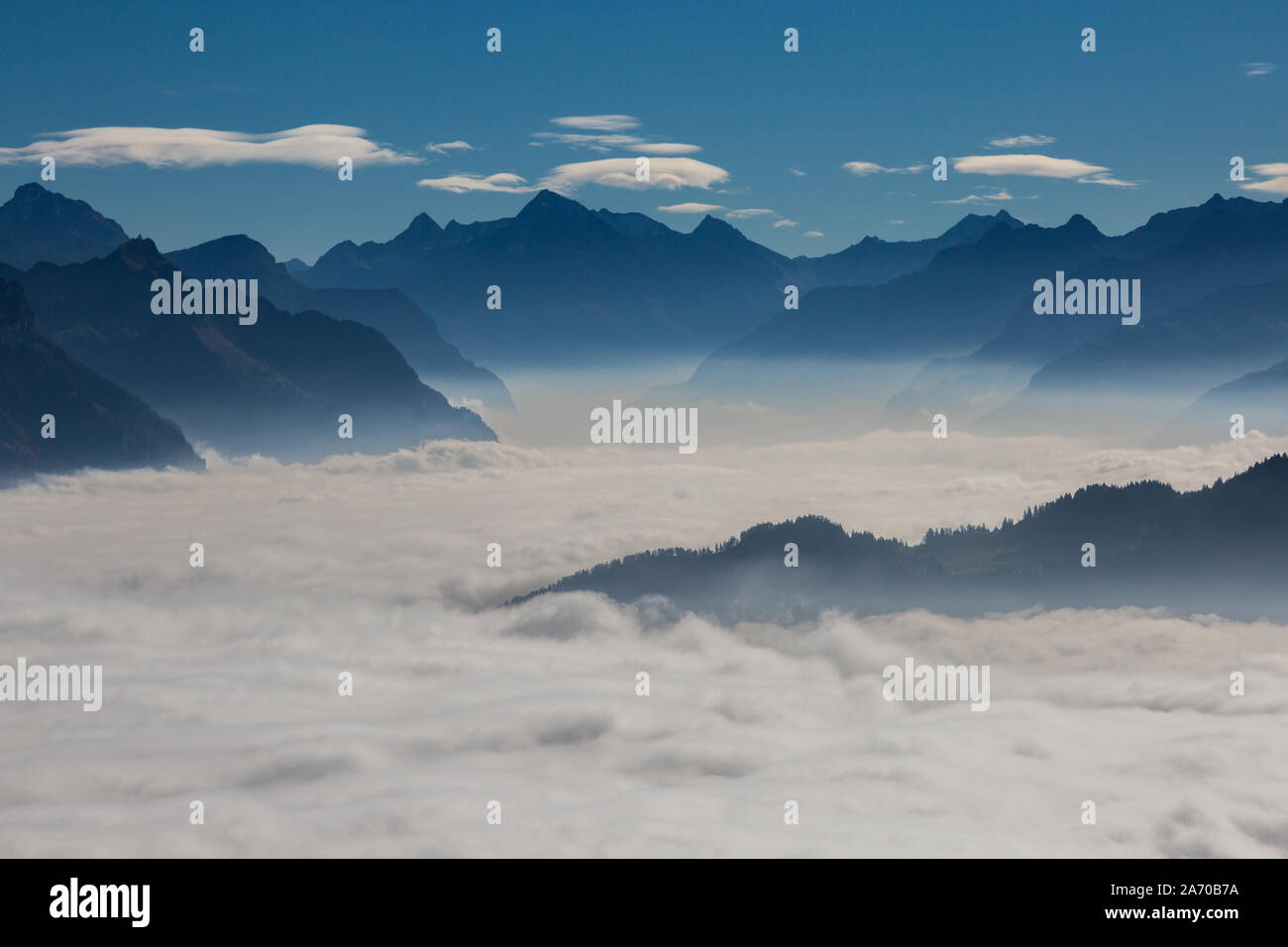 natural sea of fog over Schwyz and Uri in Swiss mountains with blue sky Stock Photo