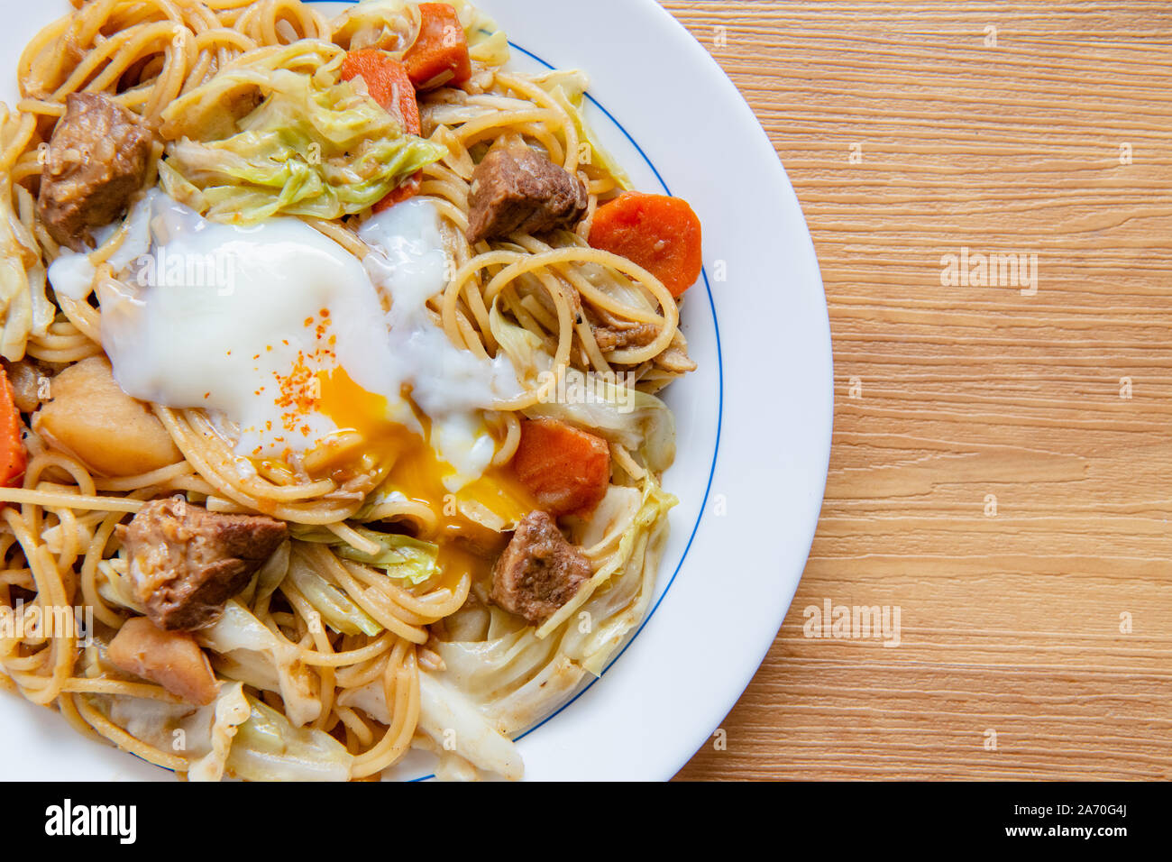 Pork Curry spaghetti  on wooden background ( Onsen tamago, Potato, enoki mushroom, onion, broccoli, Japanese style,) Stock Photo