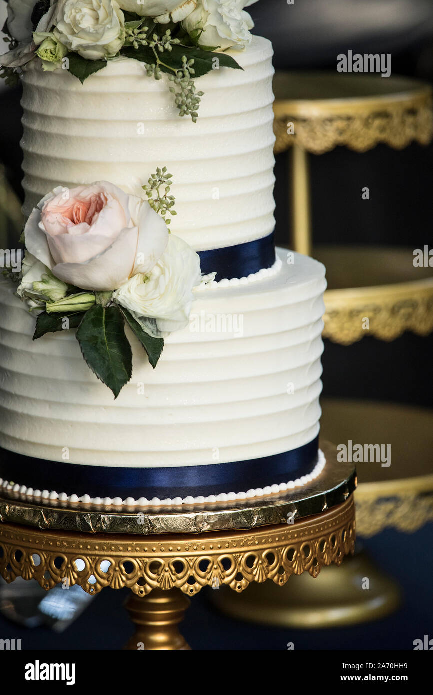 Close Up Of White Two Tiered Wedding Cake With Flowers Stock Photo