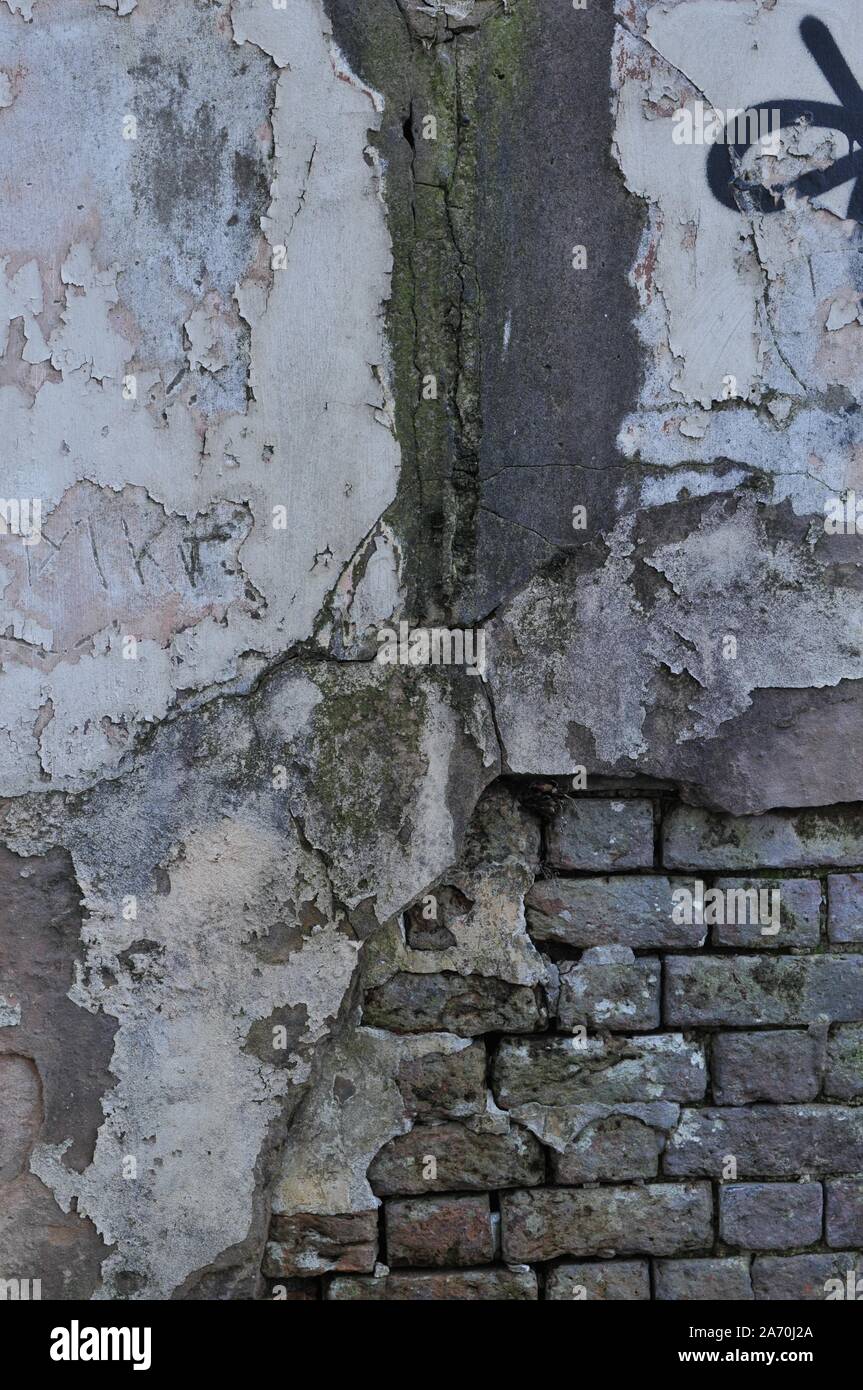 Cracked Broken Destroyed Weathered Plaster Paint on Exterior White Wall Stock Photo