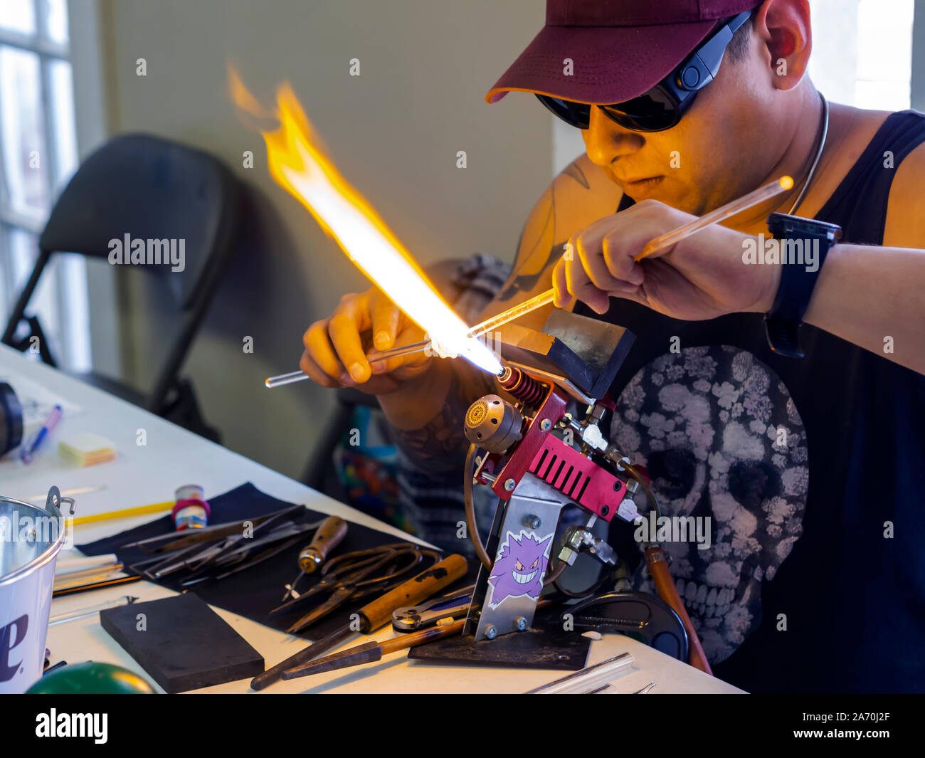 A glass blowing artist forms a blob of glass into a vessel using a gas torch  in Vermont Stock Photo - Alamy