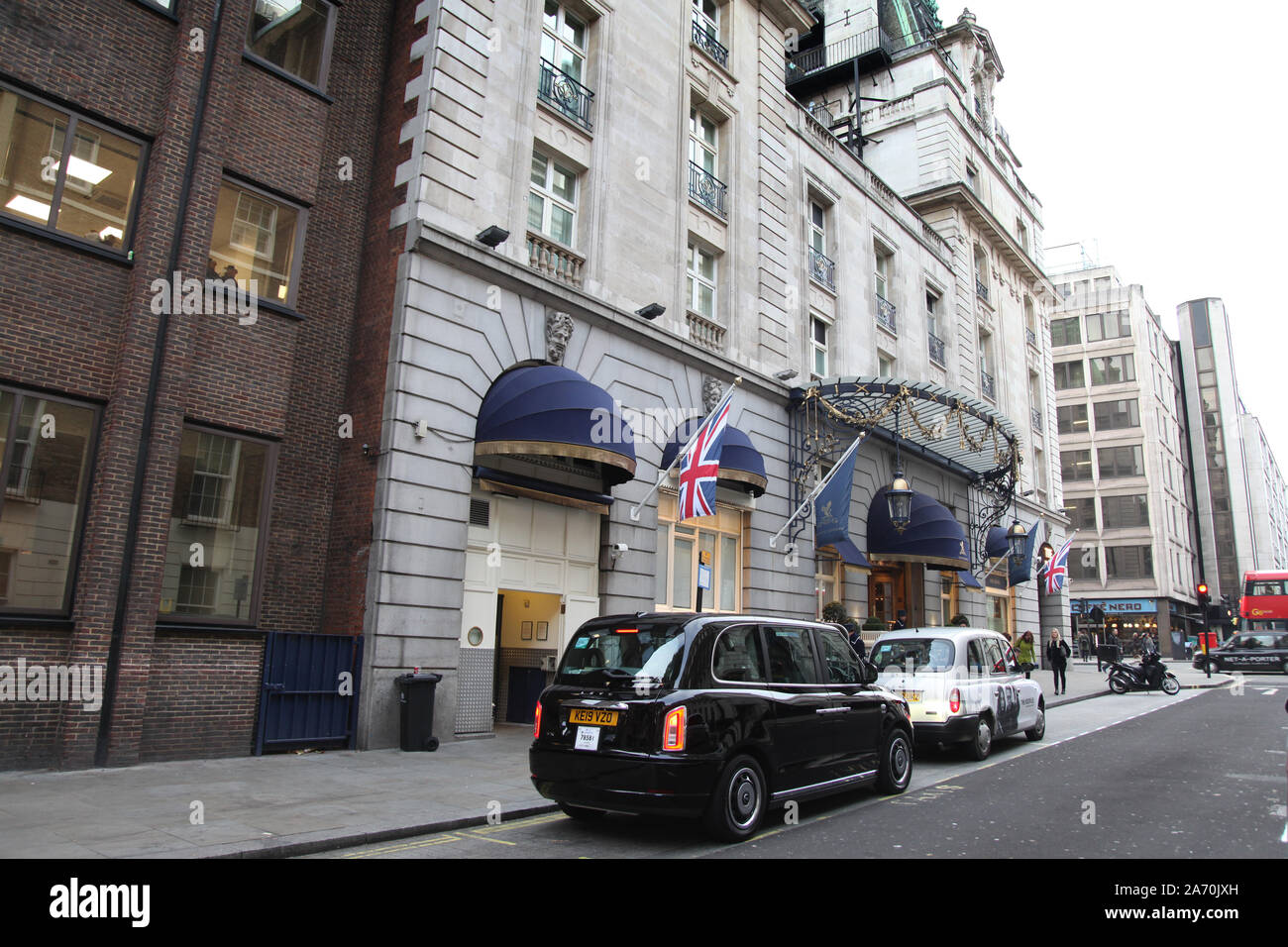 Entrance to The Ritz Hotel looking North on Arlington Street, Mayfair, London, black taxi cab parked outside Ritz hotel Stock Photo