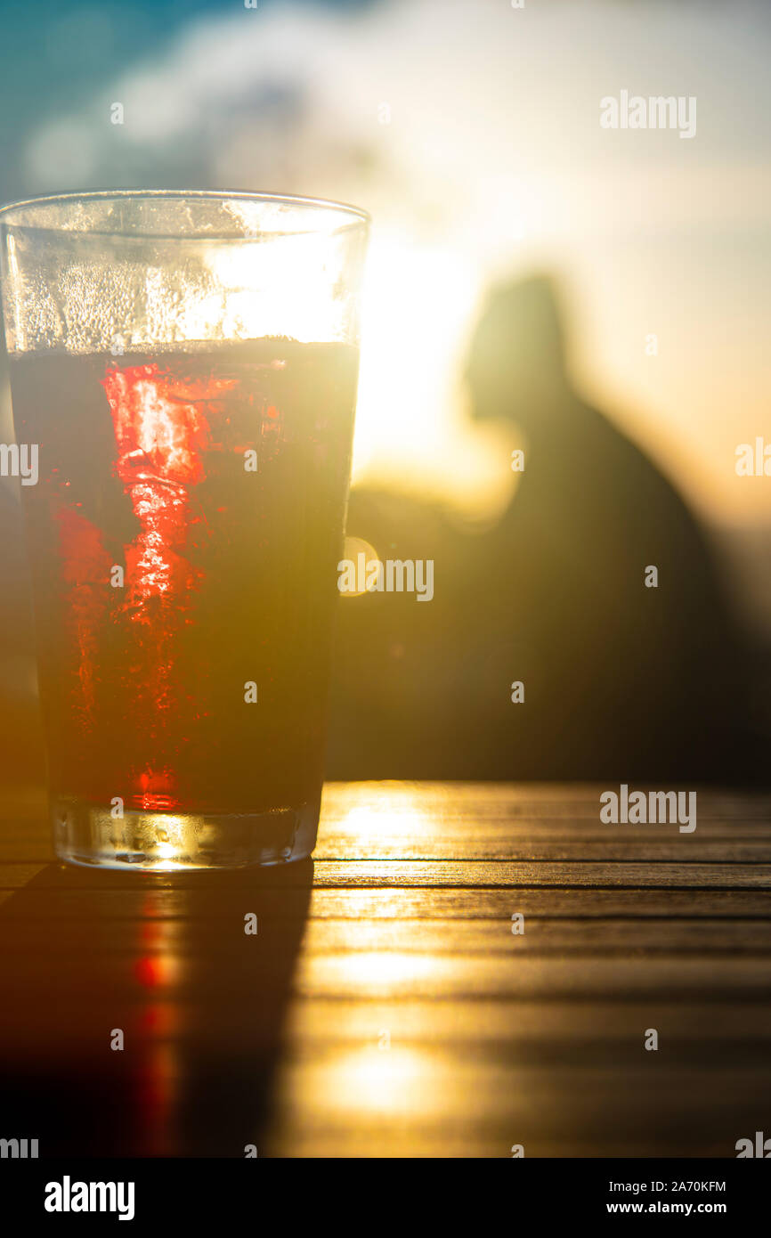 Red wine against the sun with male silhouette at background Stock Photo