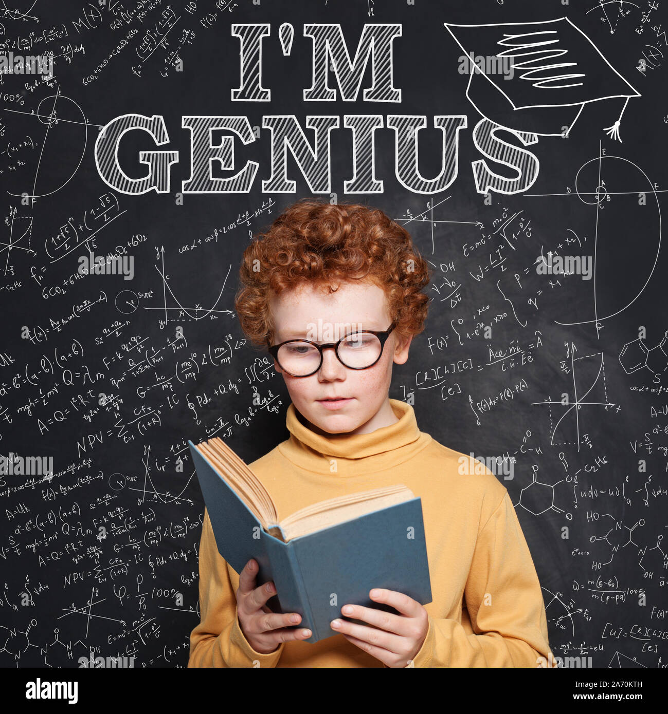 Clever little boy genius on blackboard background portrait Stock Photo