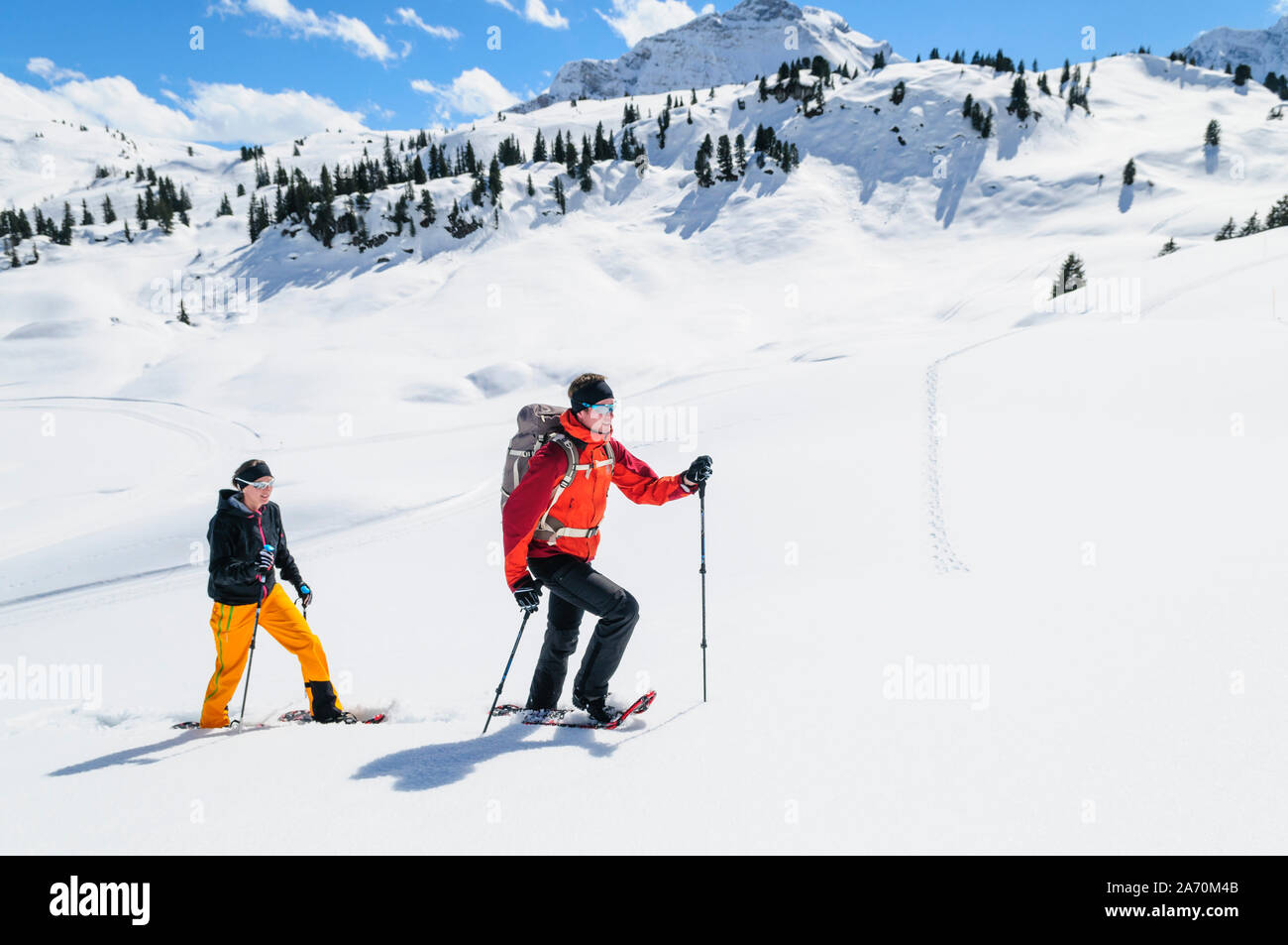 Young couple hiking with snowshoes at a beautiful day in late winter Stock Photo