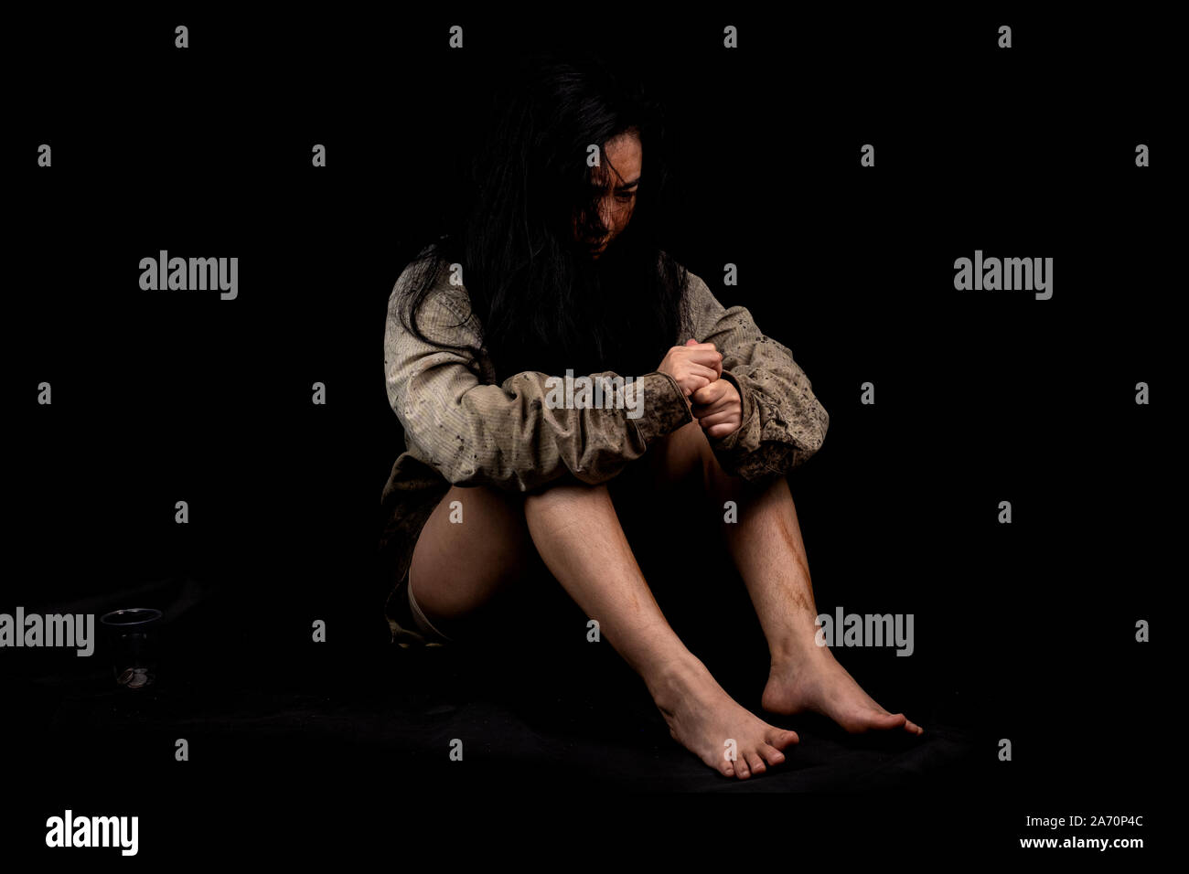 Young and dirty beggar asking for some money, Portrait of young beautiful homeless concept on black background Stock Photo