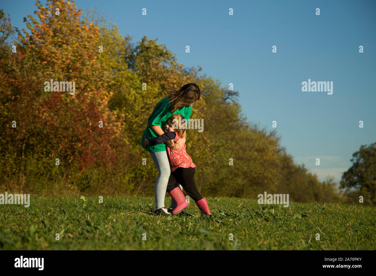 Natural portrait of young girls having fun in autumn colorful sun in nature. Stock Photo