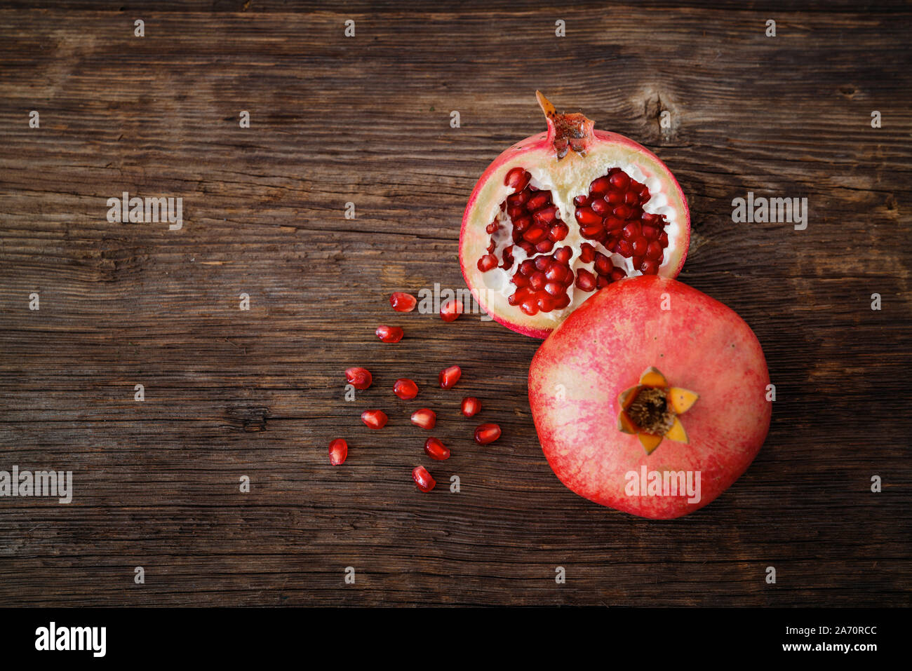 Ripe and fresh pomegranate peeled and ready for eat on wooden beackground. Stock Photo