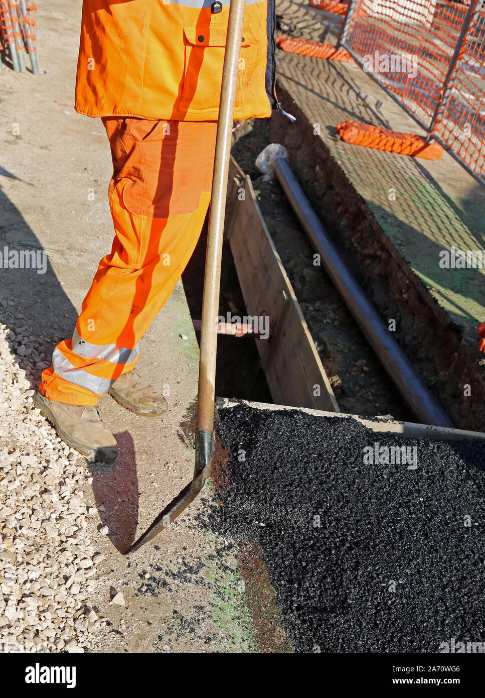 man at work high visibility clothing while working on a road construction site Stock Photo