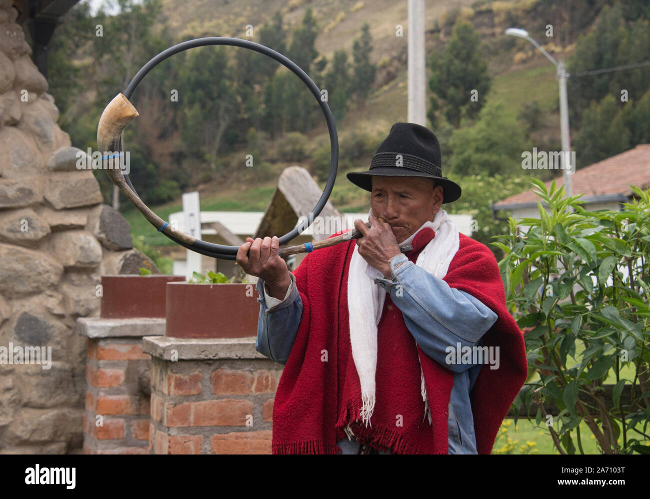 Indigenous highlander playing a cow horn trumpet, La Moya, Ecuador Stock Photo