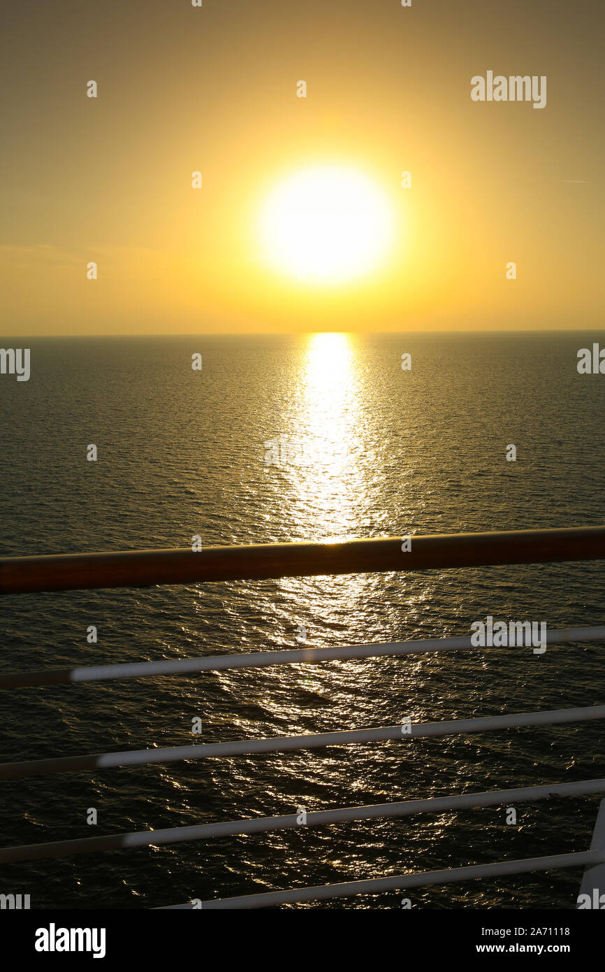 Sunset from the deck of a cruise ship with reflections over the sea, cruising the Indian Ocean. Stock Photo