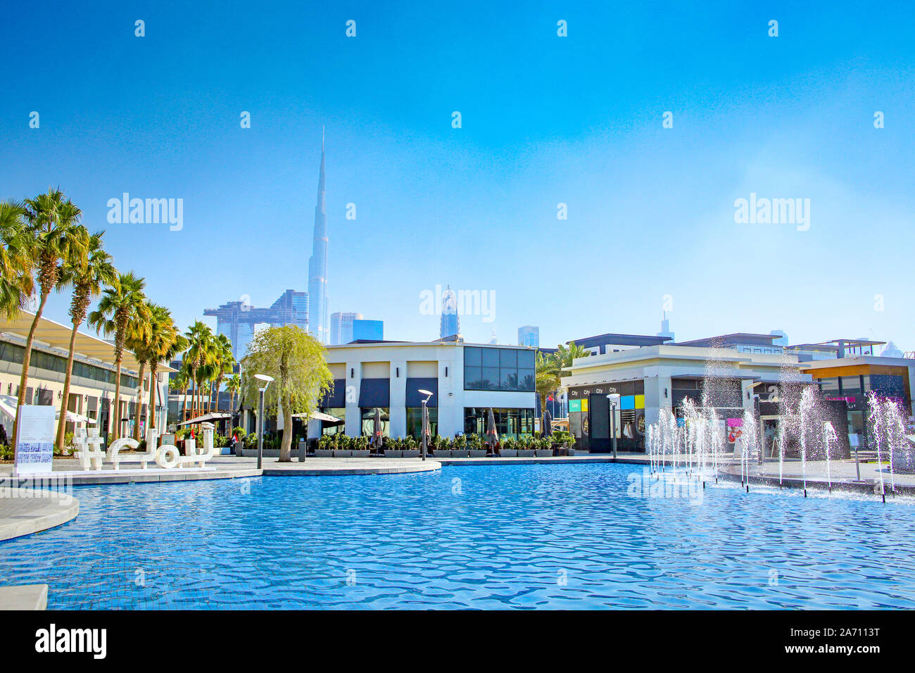 Shopping center in the city with shops surrounding a swimming pool & skyscrappers in the background, Dubai, United Arab Emirates. Stock Photo