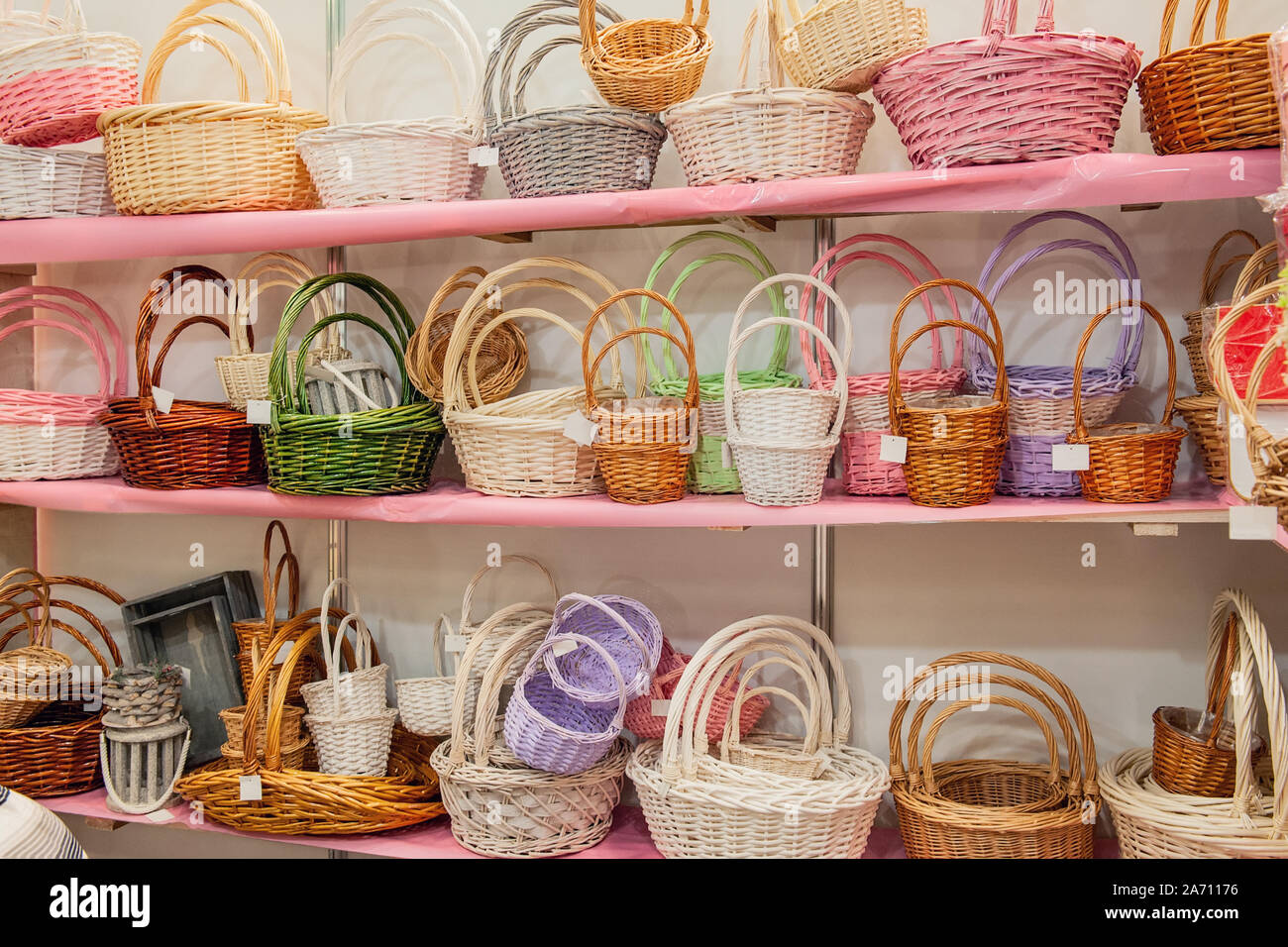 Handmade wicker colorful baskets of different sizes on the shelf of the market. Handmade crafts. Reusable packaging. No plastic bags. Selective focus. Stock Photo