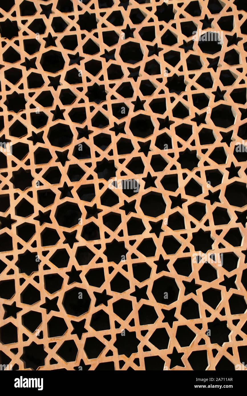 Geometric pattern made up of stars, triangles & shapes, in a gold colour against black. Stock Photo