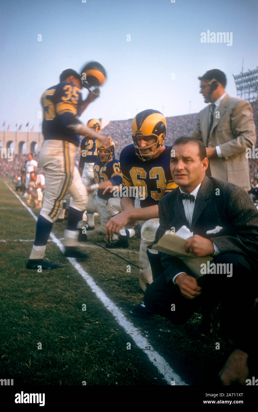 LOS ANGELES, CA - NOVEMBER 10: John Hock #63 and head coach Sid Gillman of the Los Angeles Rams kneel on sideline during an NFL game against the San Francisco 49ers on November 10, 1957 at the Los Angeles Coliseum in Los Angeles, California. (Photo by Hy Peskin) Stock Photo