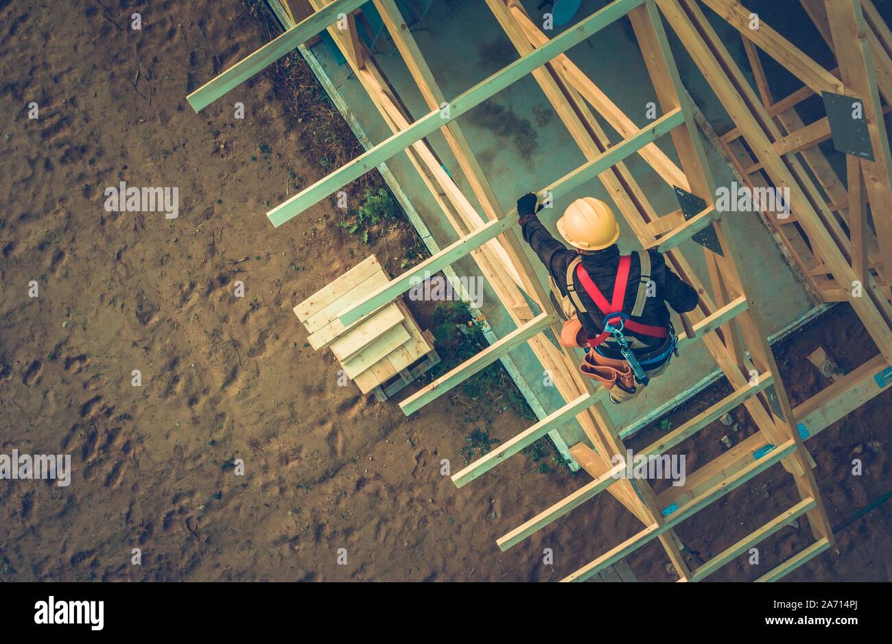 Wooden Roof Frame Building. Caucasian Roofer Working at Height. Industrial Theme. Stock Photo