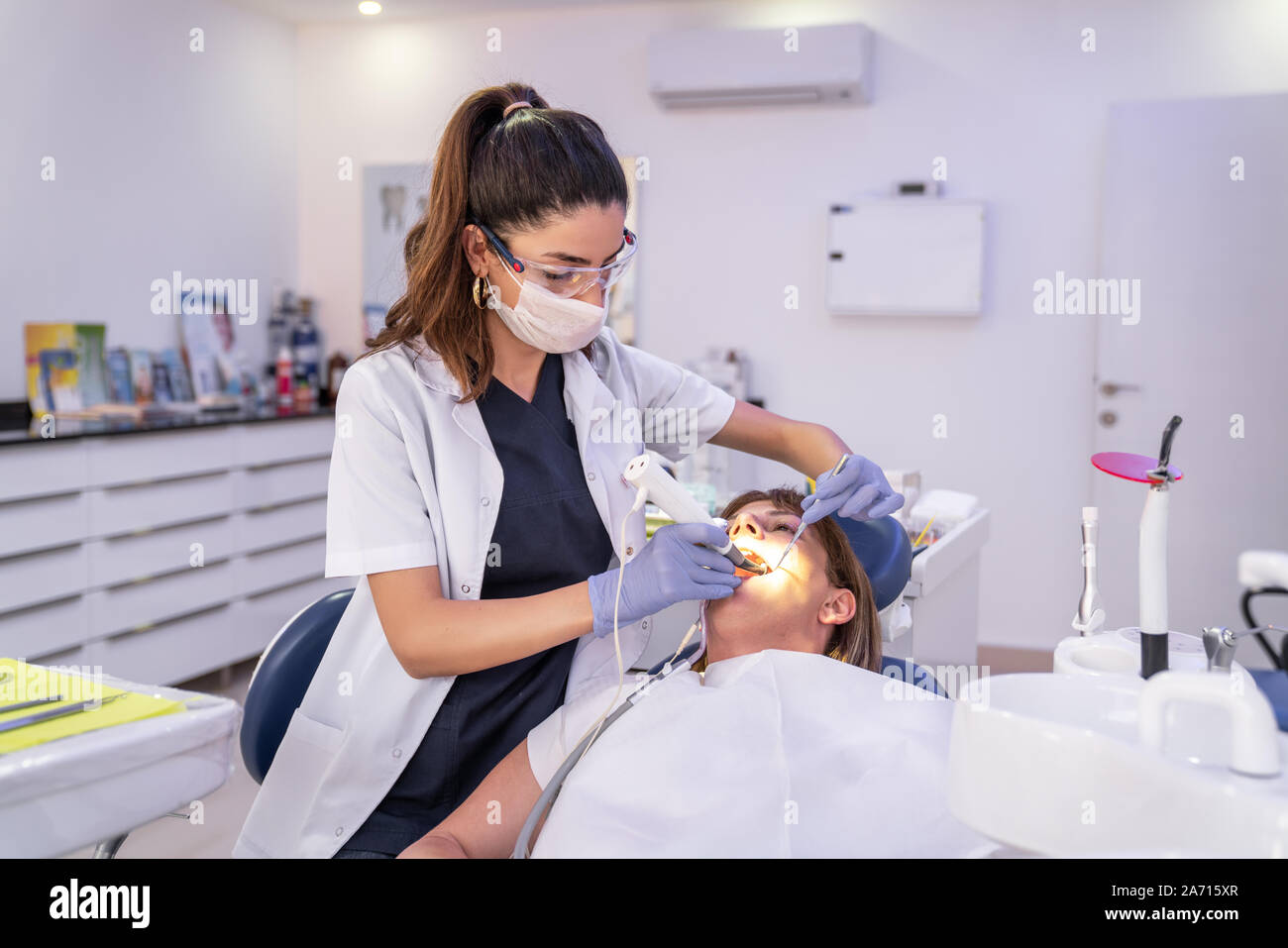 Woman is getting dental treatment in a dental clinic. Stock Photo