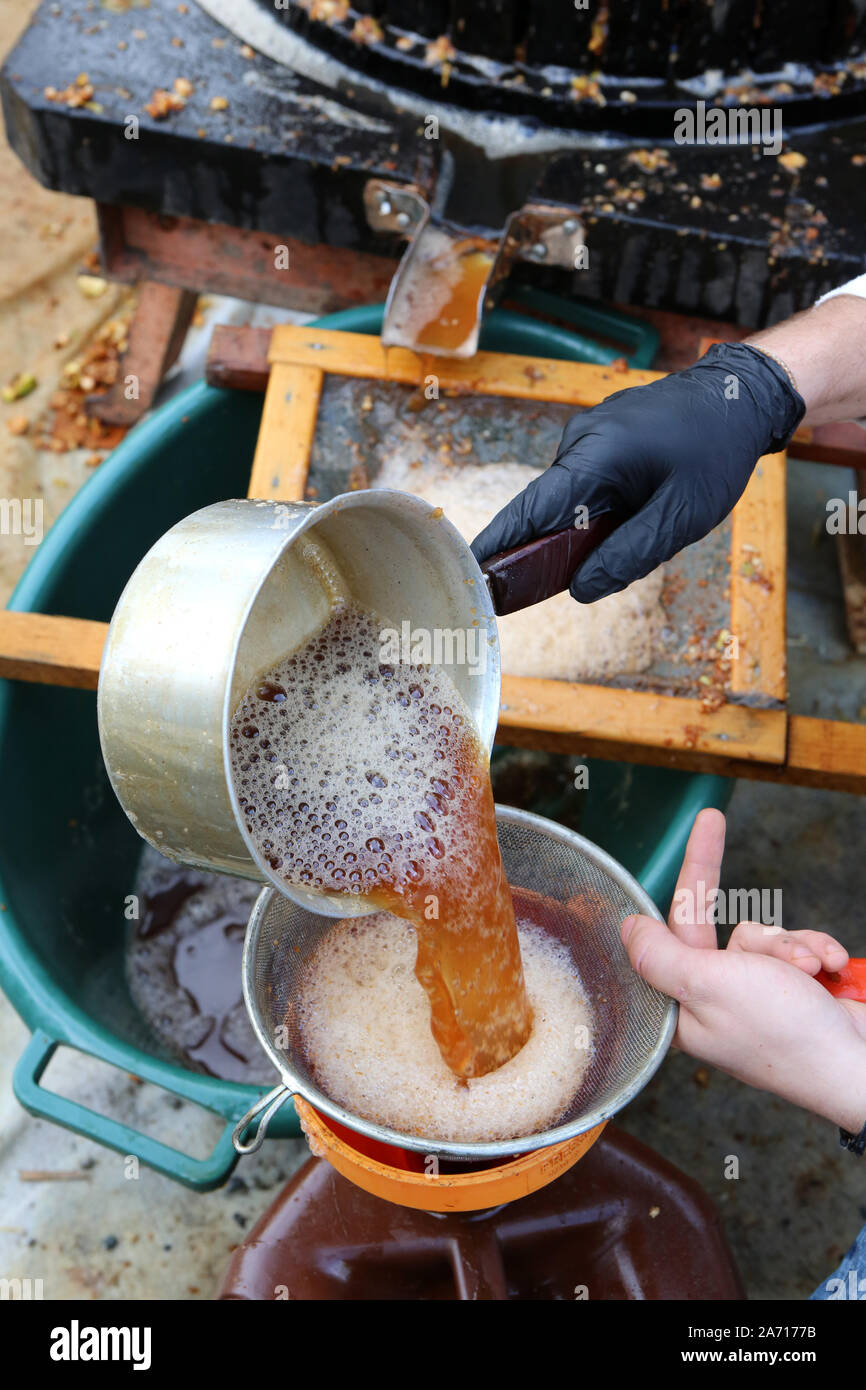 Fabrication de jus de pomme. Verser le jus de pomme dans un tamis. Haute-Savoie. France. Stock Photo