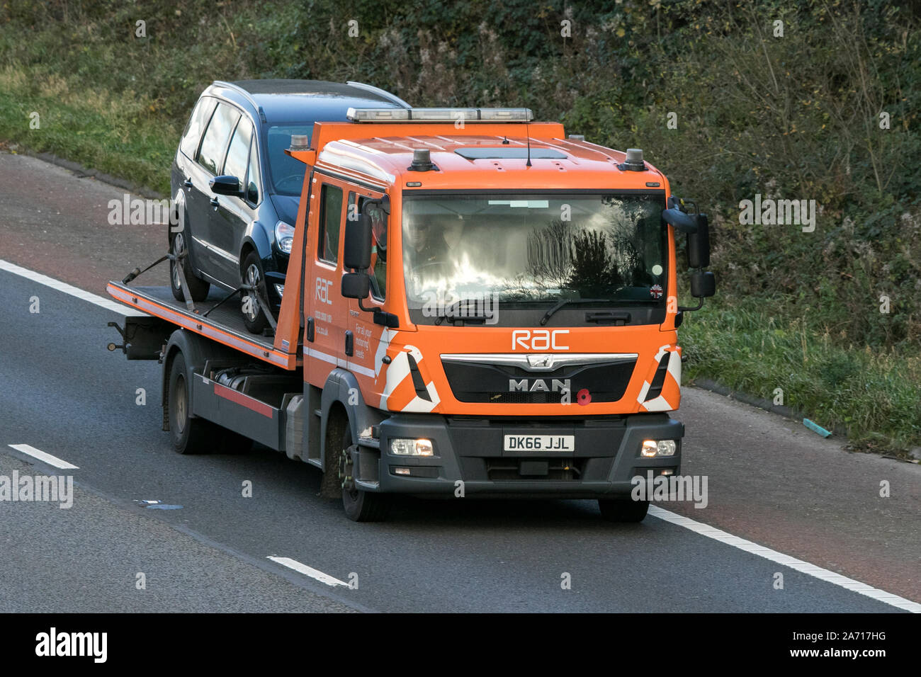 A MAN 24hr roadside RAC flatbed vehicle breakdown recovery truck traveling northbound on the M6 motorway near Garstang in Lancashire, UK Stock Photo