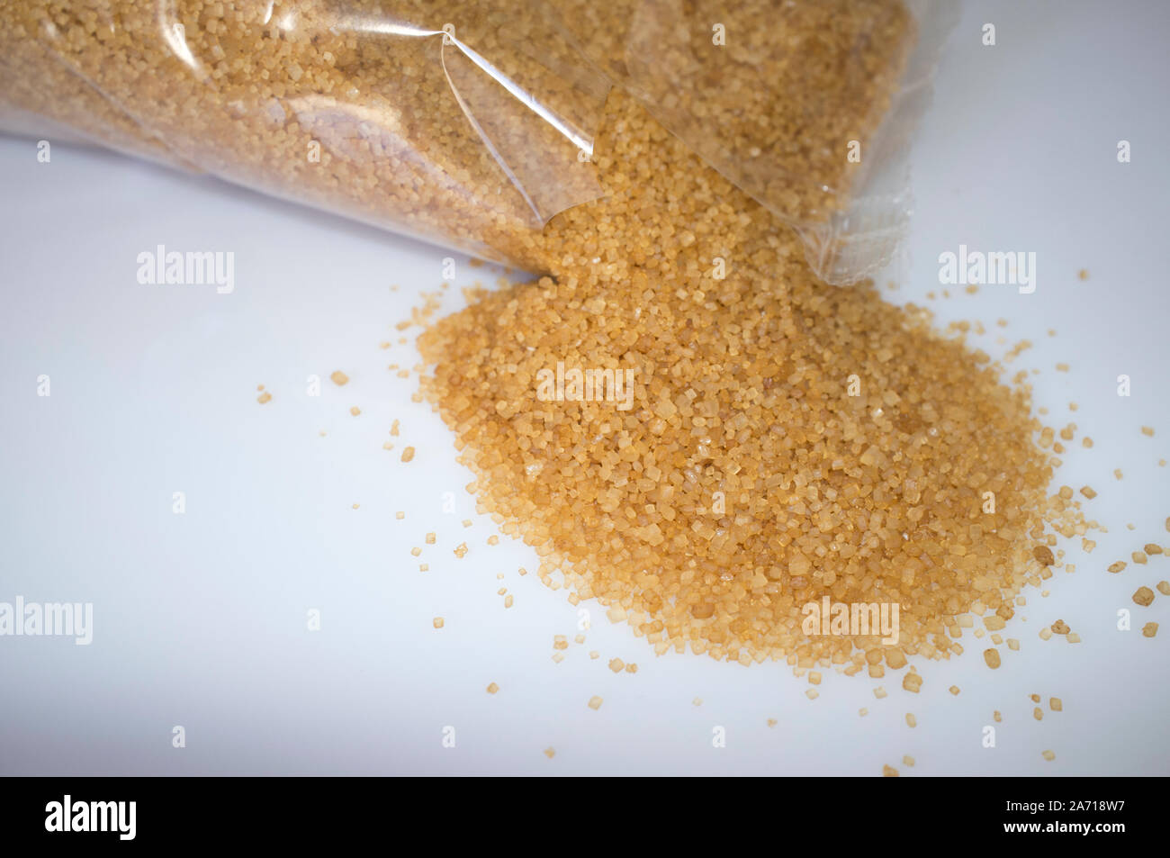 Plastic bag with spilled brown sugar. Close-up Stock Photo
