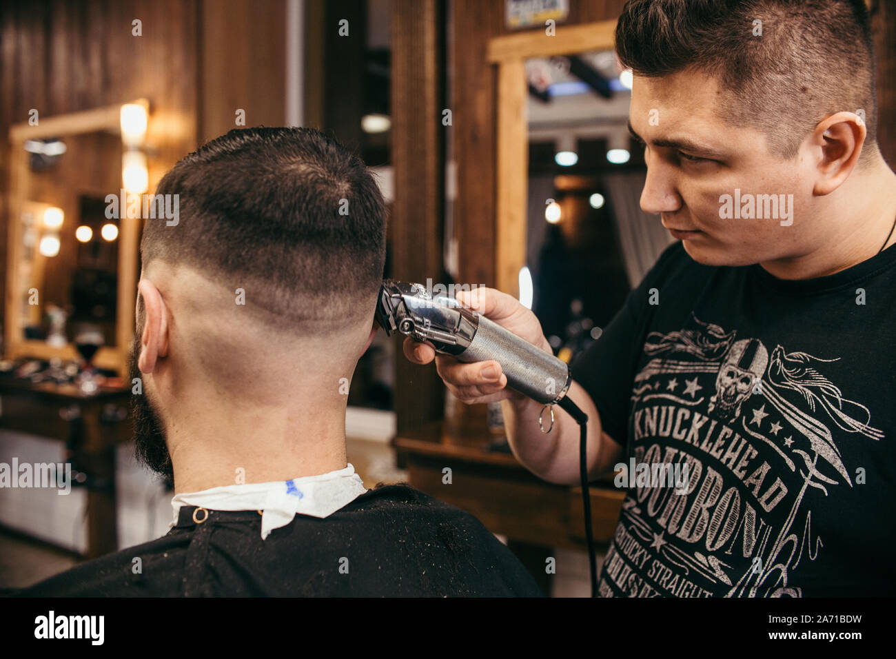 Barber shop, a man with a beard cut hairdresser. Professional haircut,  retro hairstyle and styling. Beautiful hair and care, hair salon for men.  Custo Stock Photo - Alamy