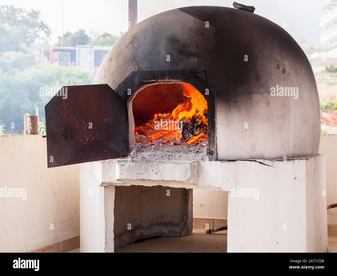 Traditional Greek and Cyprus kleftiko oven with burning fire inside Stock Photo
