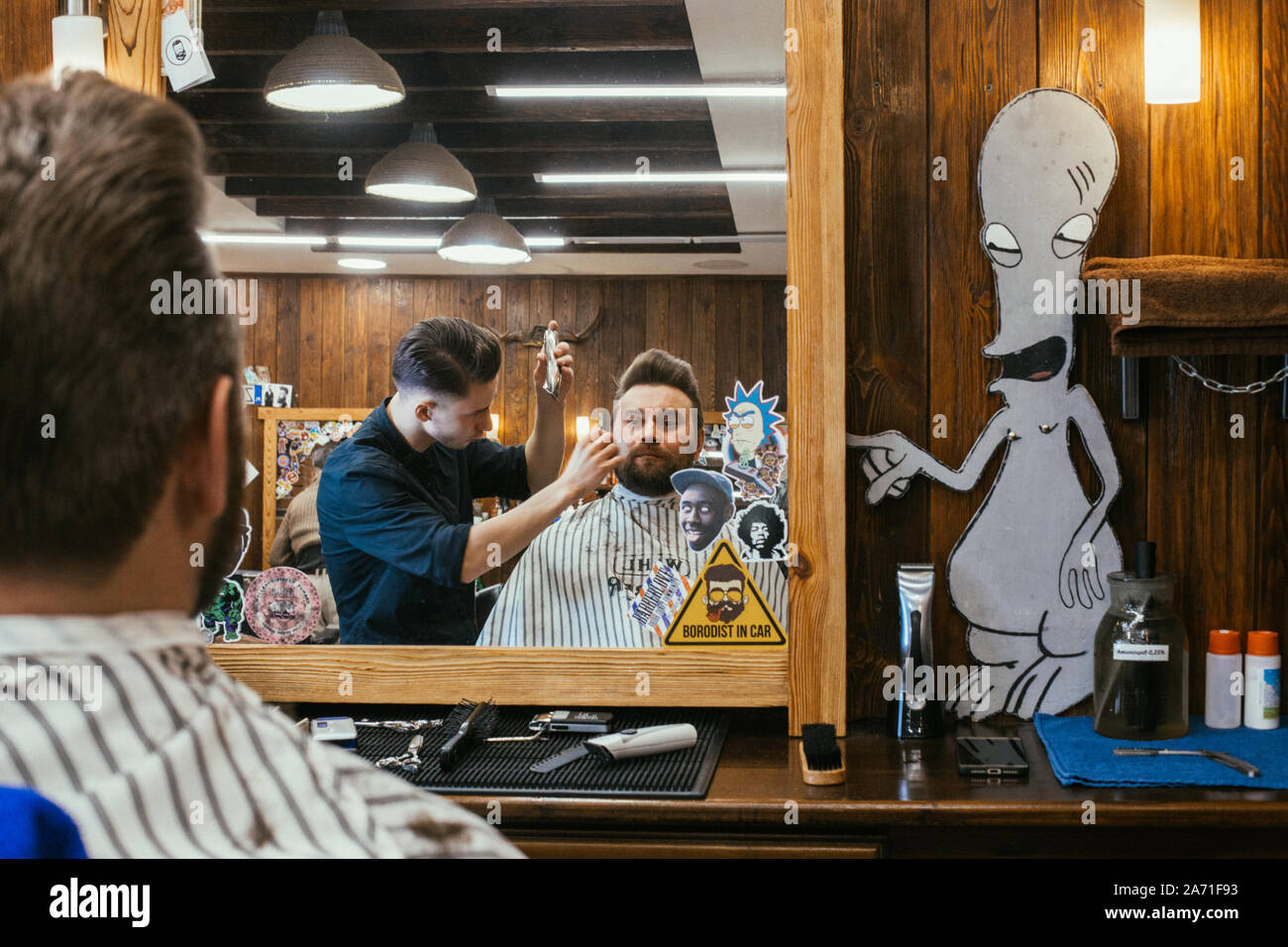 Barber shop, a man with a beard cut hairdresser. Beautiful hair and care, hair salon for men. Professional haircut, retro hairstyle and styling. Custo Stock Photo