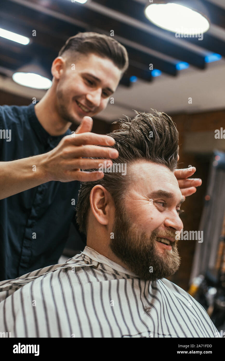 Barber shop, a man with a beard cut hairdresser. Beautiful hair and care,  hair salon for men. Professional haircut, retro hairstyle and styling.  Custo Stock Photo - Alamy