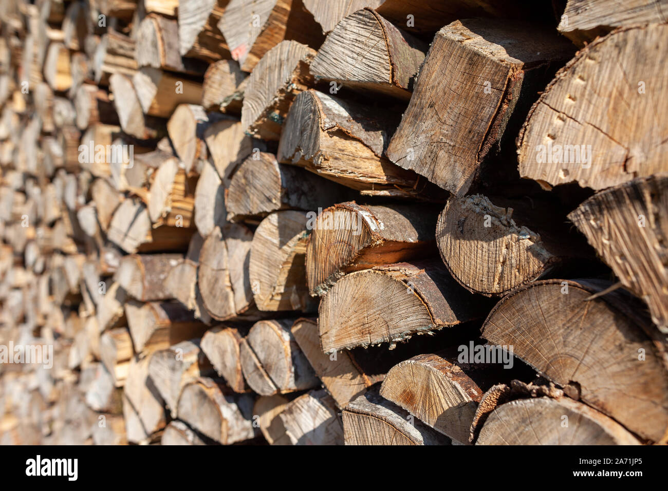 A pile of wood stacked in front of the house for long and cold winters. The wood is to keep the fire place warm and the fire going. Stock Photo