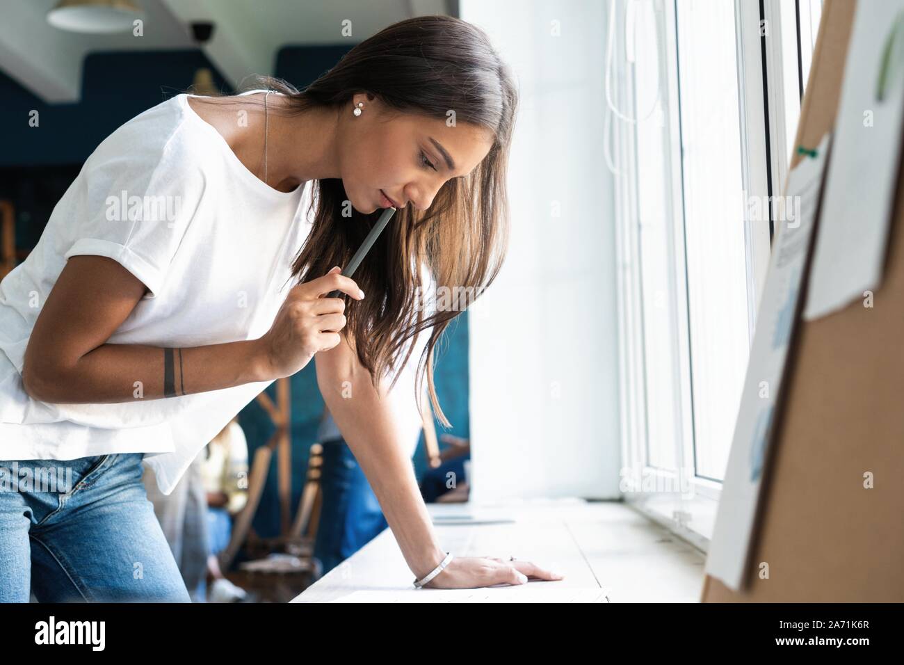 Portrait of young female architect working on project. Stock Photo