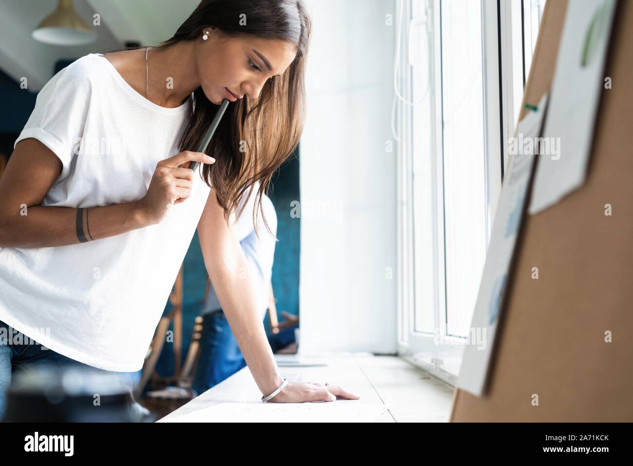 Portrait of young female architect working on project. Stock Photo