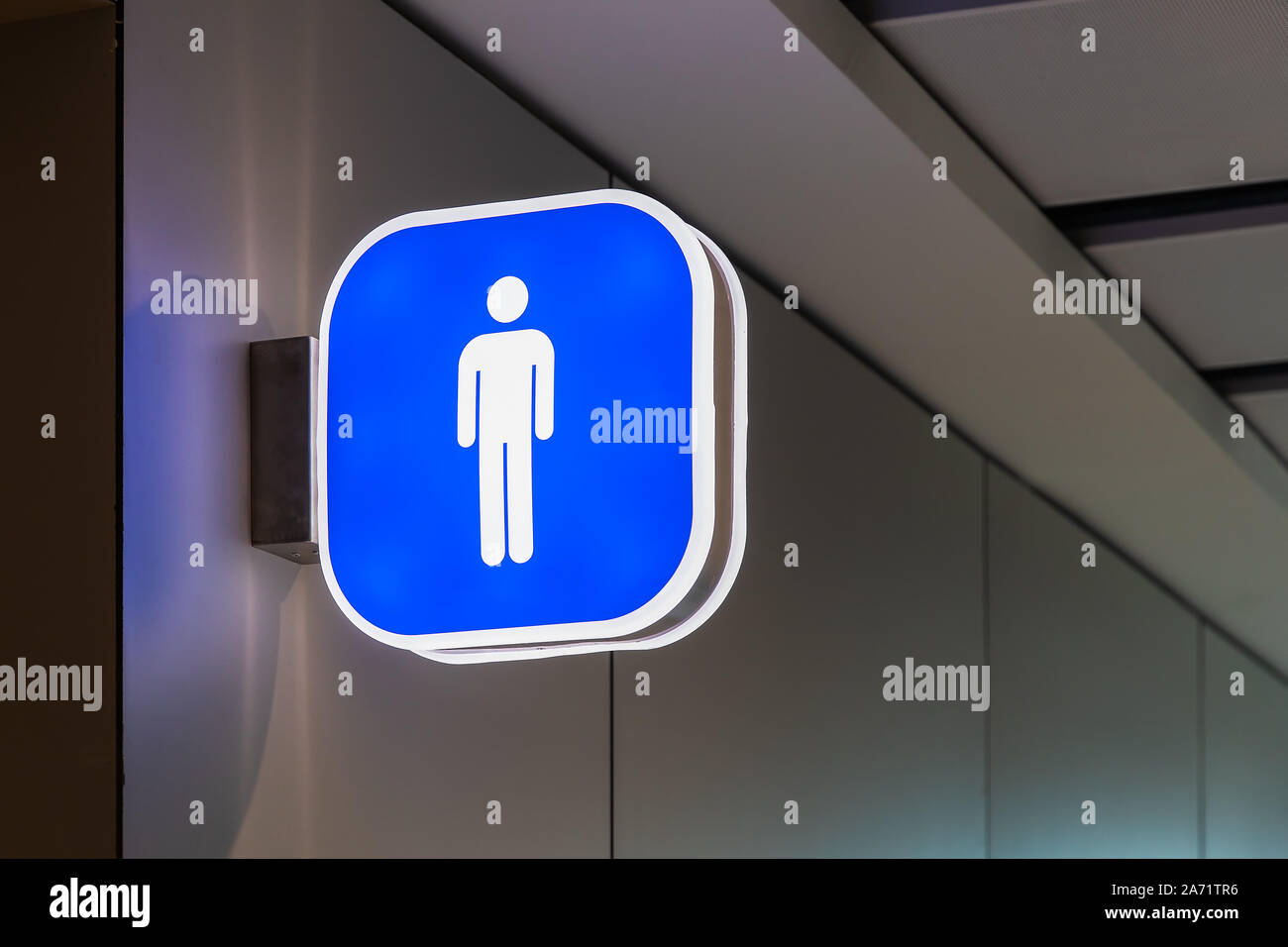 ISTANBUL, Turkey august 2019: international airport restroom sign for man hanging on the wall, pictogram in blue and white, background in colour Stock Photo
