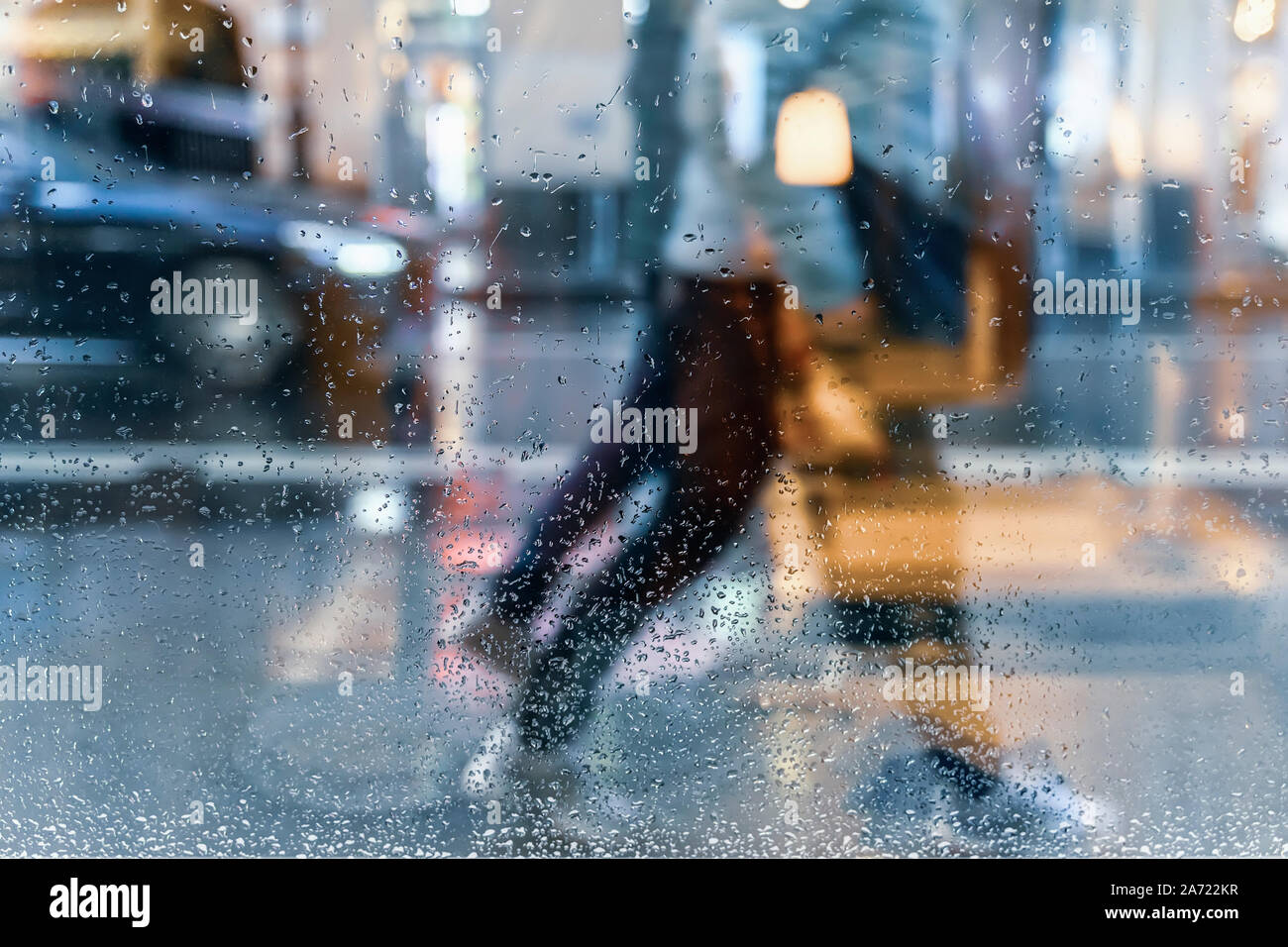 Blurry reflection silhouettes of the people in walking on a rain, night ...