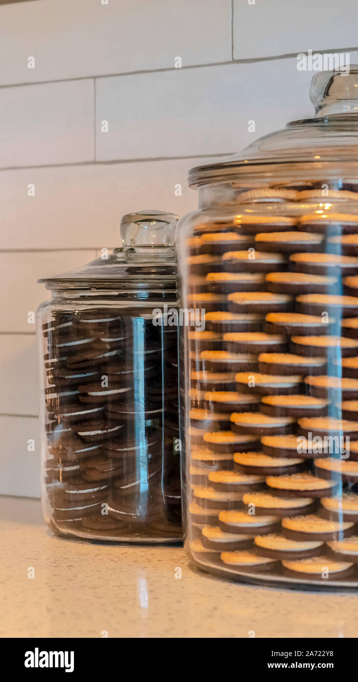 Vertical Large glass jars filled with cookies in kitchen Stock