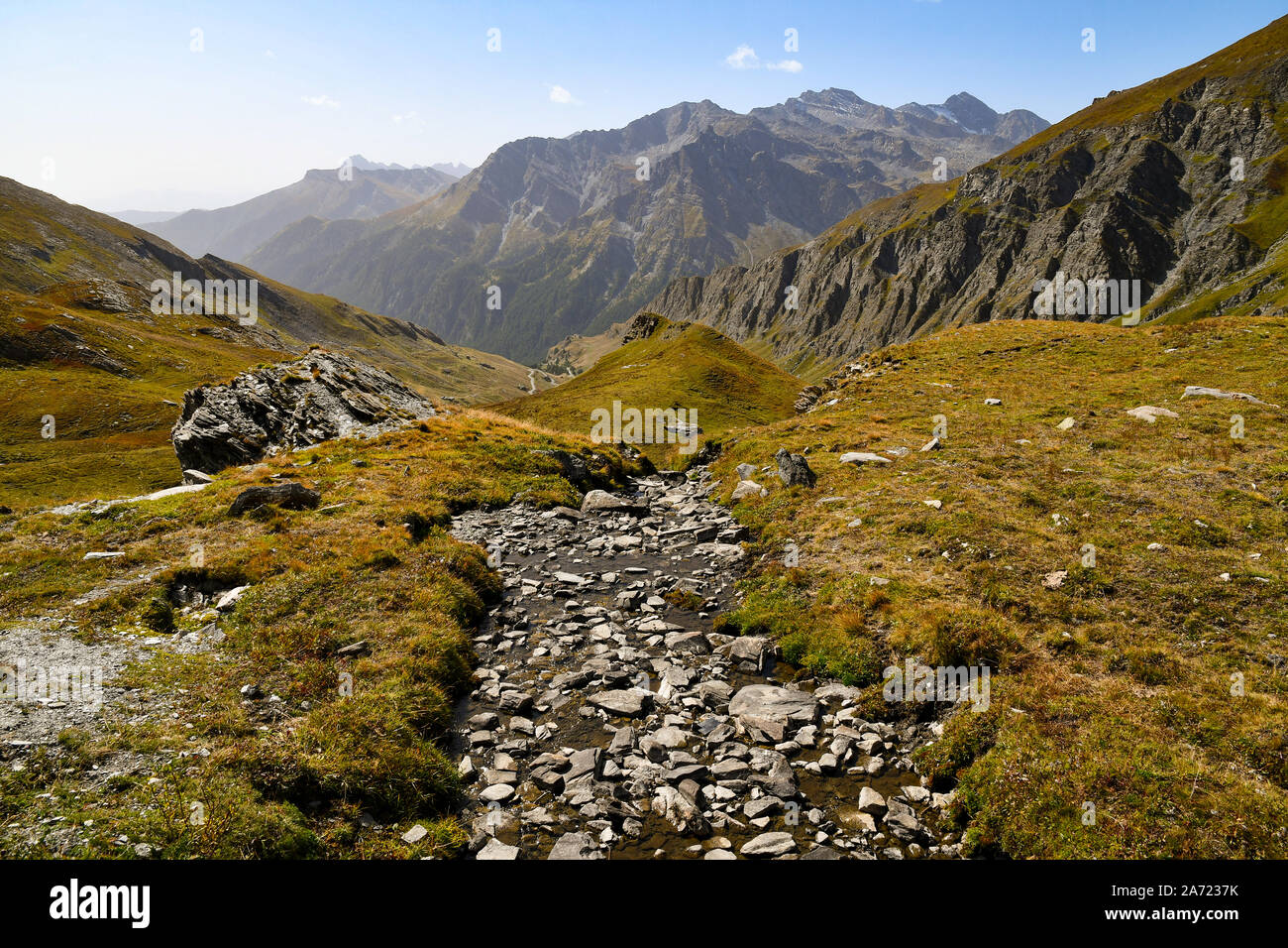 Scenic view of Colle dell'Agnello mountain pass in the Italian Alps with a stream and rocky peaks in late summer, Chianale, Cuneo, Piedmont, Italy Stock Photo