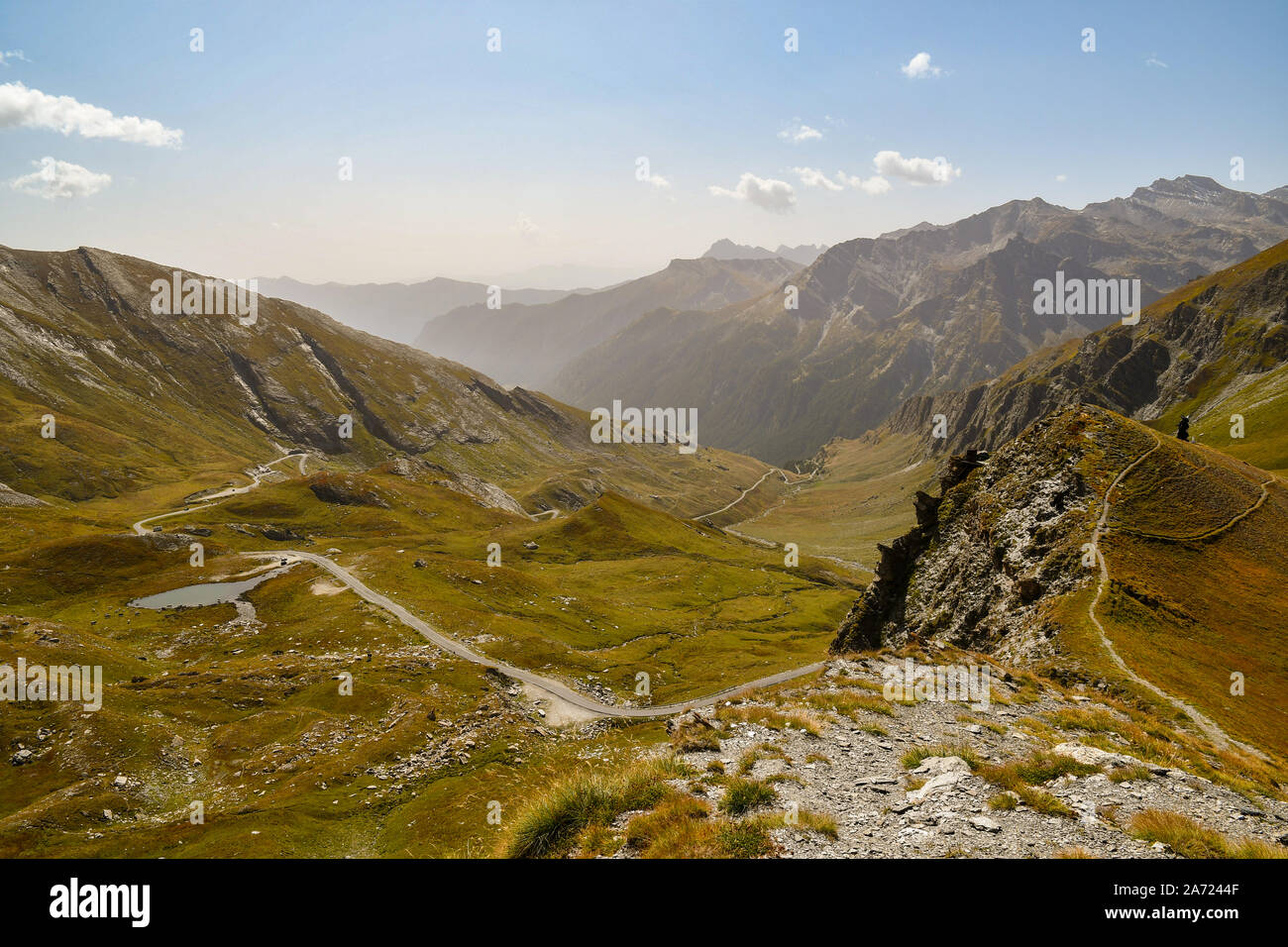 Elevated view of Colle dell'Agnello mountain pass with the winding road and the Lake of Pic d'Asti in late summer, Chianale, Cuneo, Piedmont, Italy Stock Photo