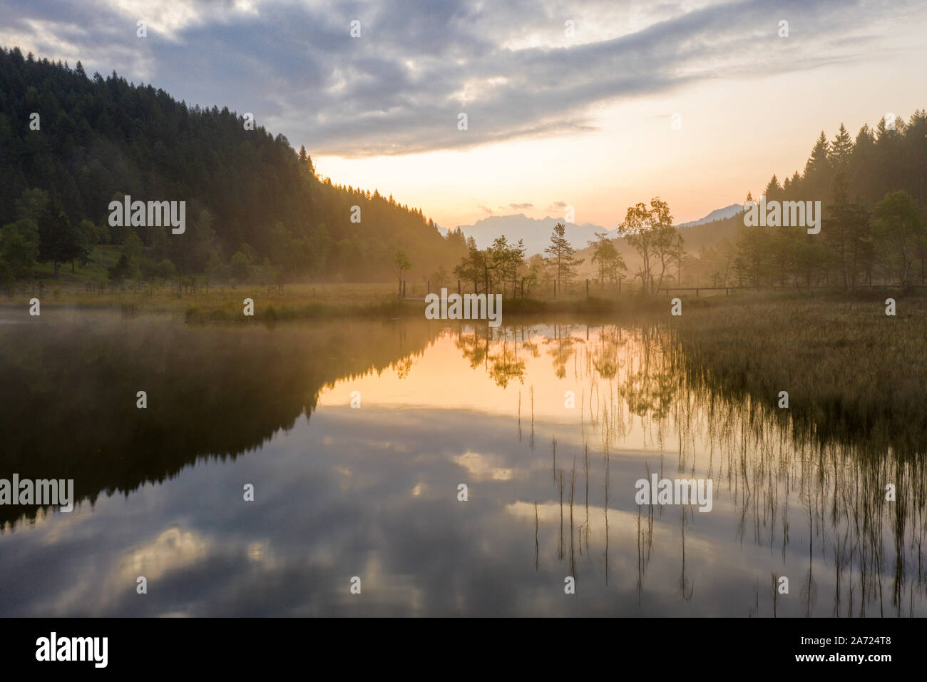 Sunrise over trees mirrored in swamp, Pian di Gembro Nature Reserve, aerial view, Aprica, Valtellina, Lombardy, Italy Stock Photo