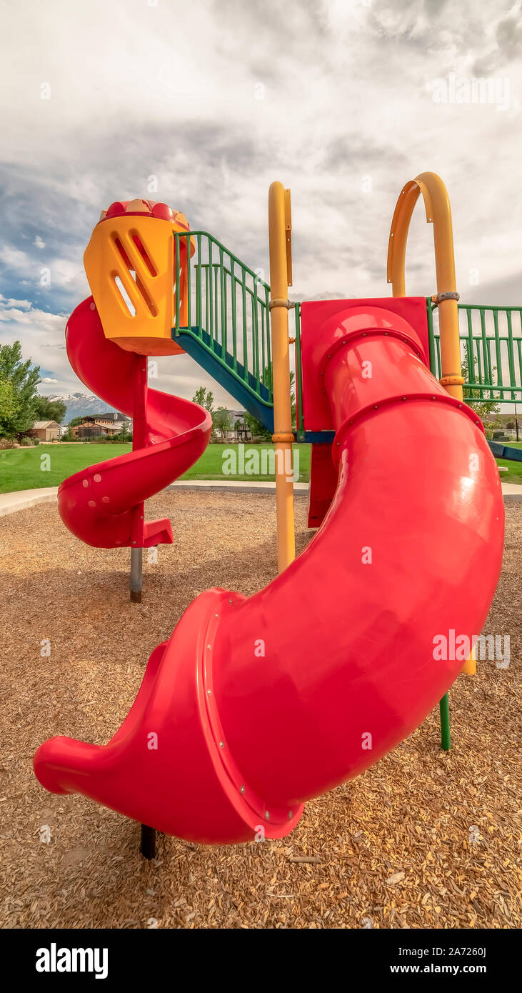 Vertical Red closed tube slide and spiral slide at a playground