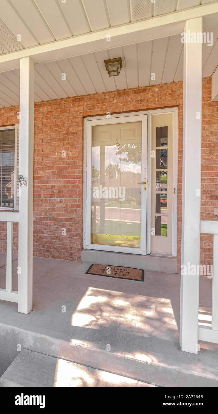 Vertical Front porch and door of traditional brick home Stock Photo - Alamy