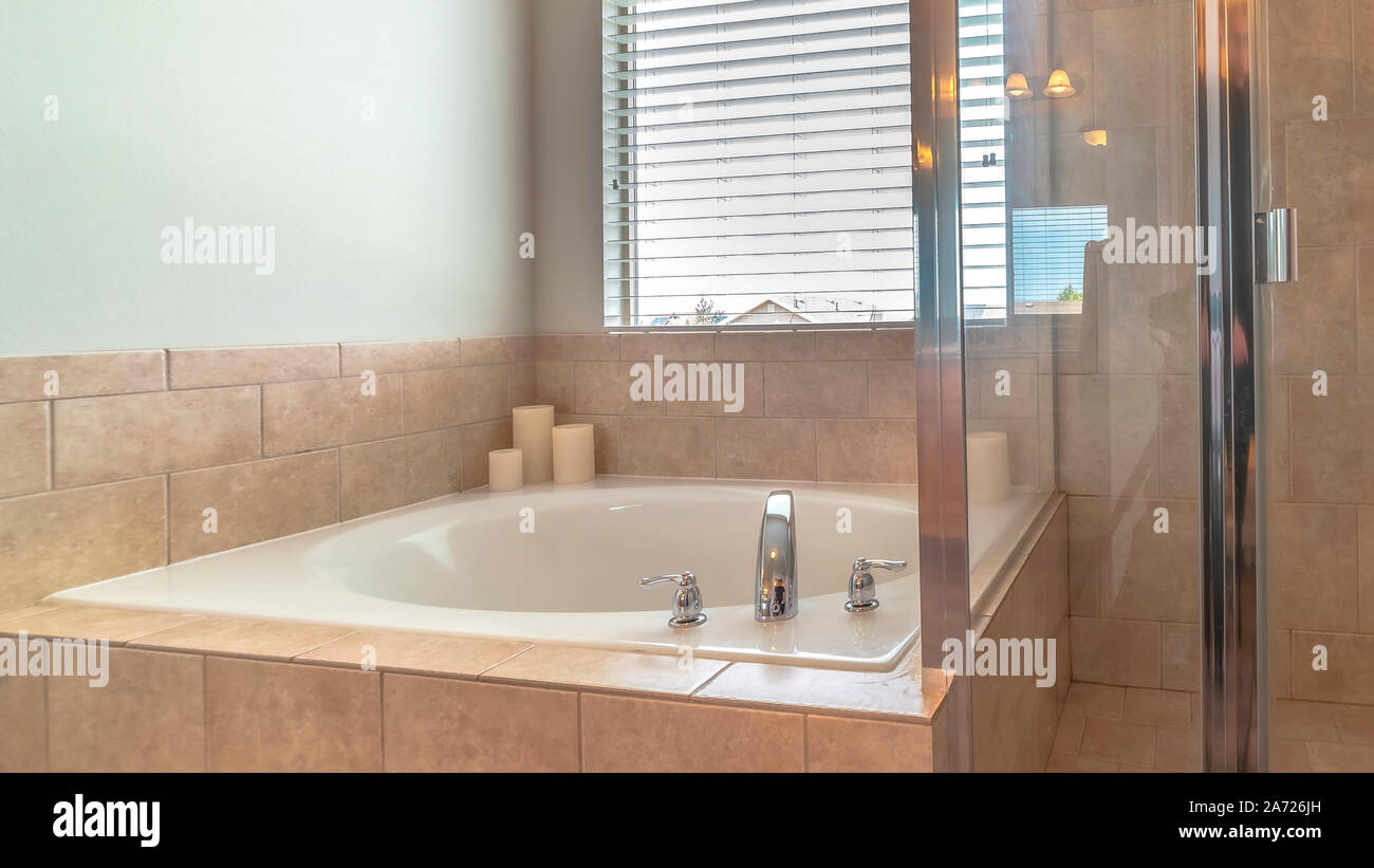 Panorama Glass walled shower stall and circular bathtub inside modern bathroom of home Stock Photo