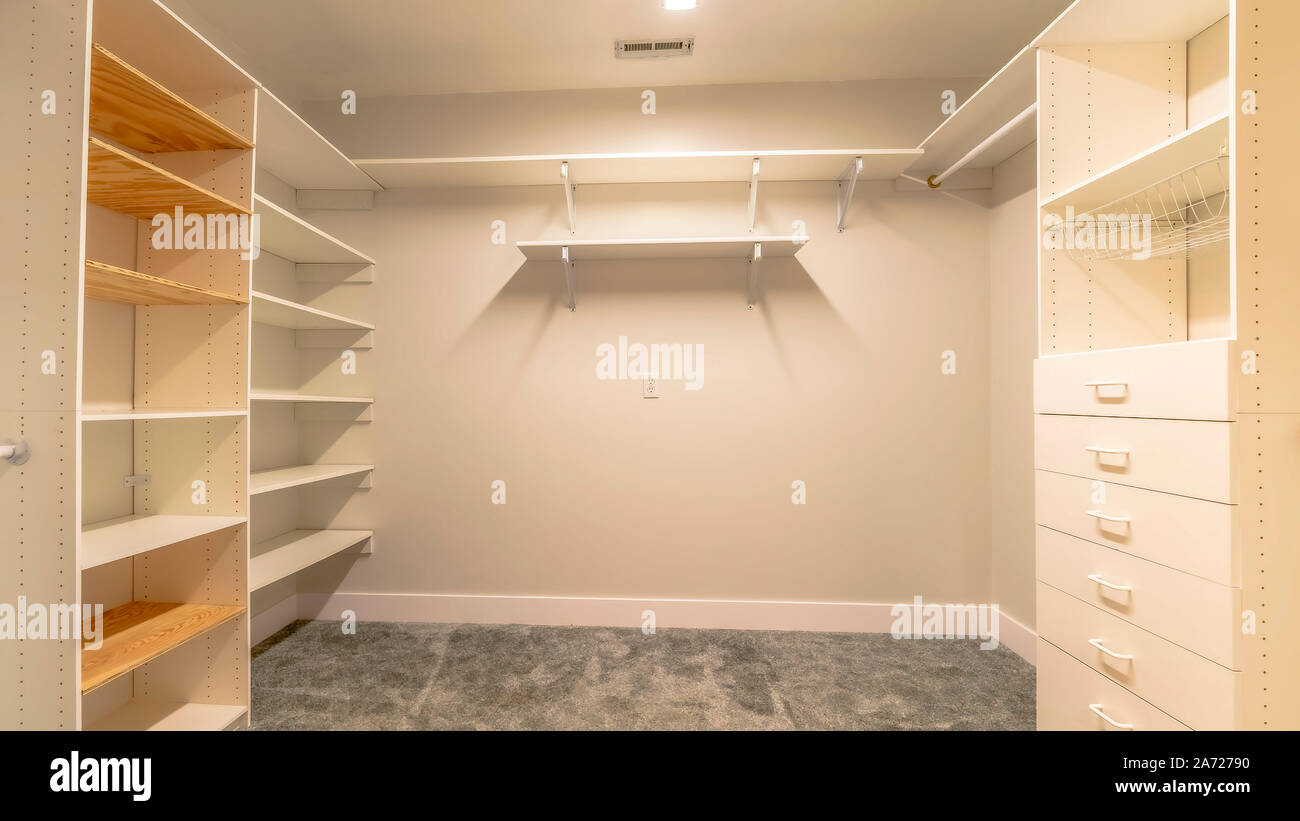 Panorama Empty walk in closet of a new house with shelves cabinets and ...