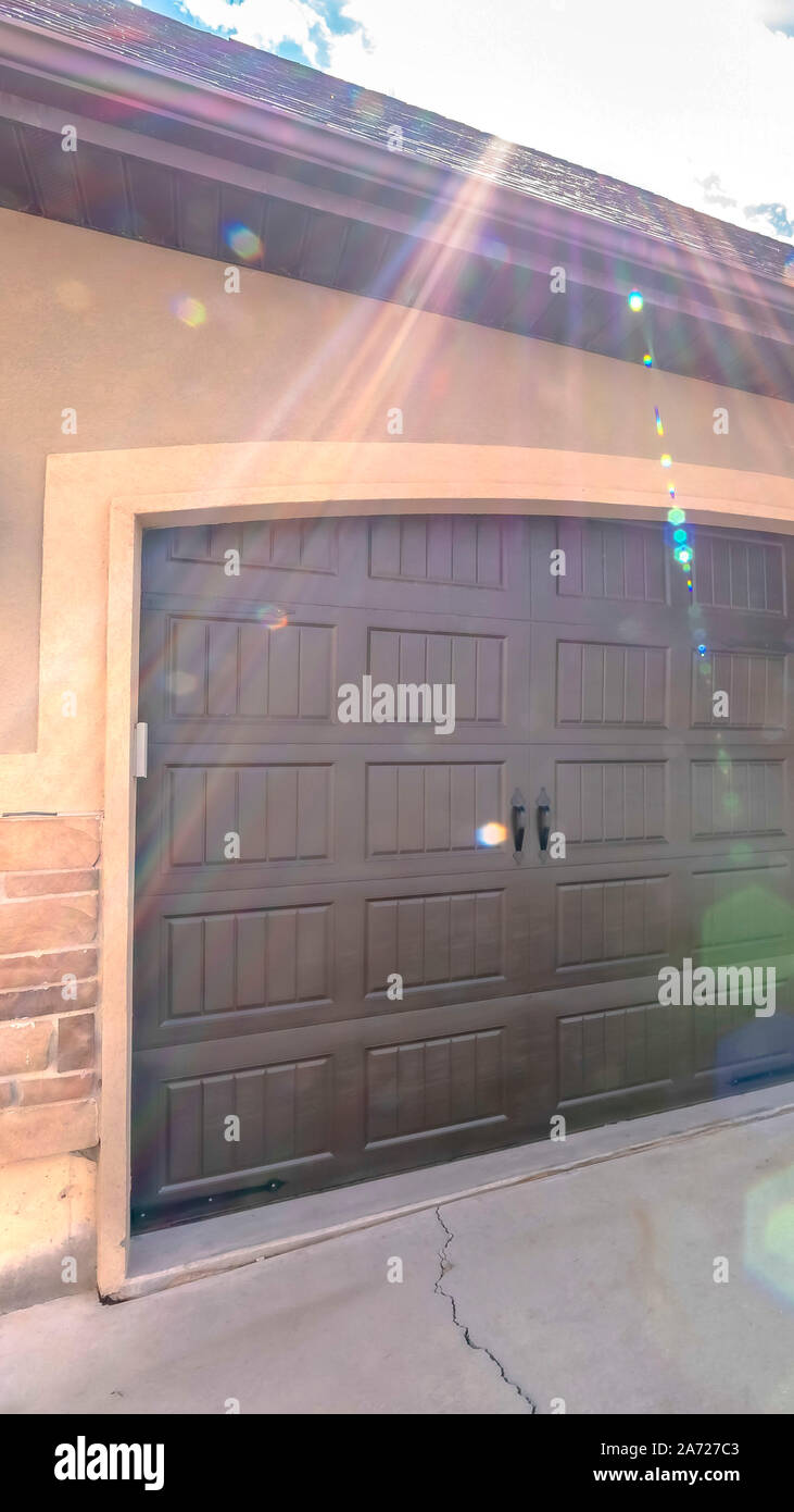 Vertical Exterior Of A Home With Wide Arched Garage Door Against