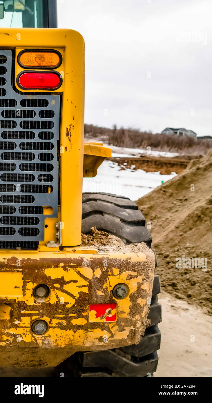 Vertical Focus on the rear of an old yellow bulldozer against snowy ...
