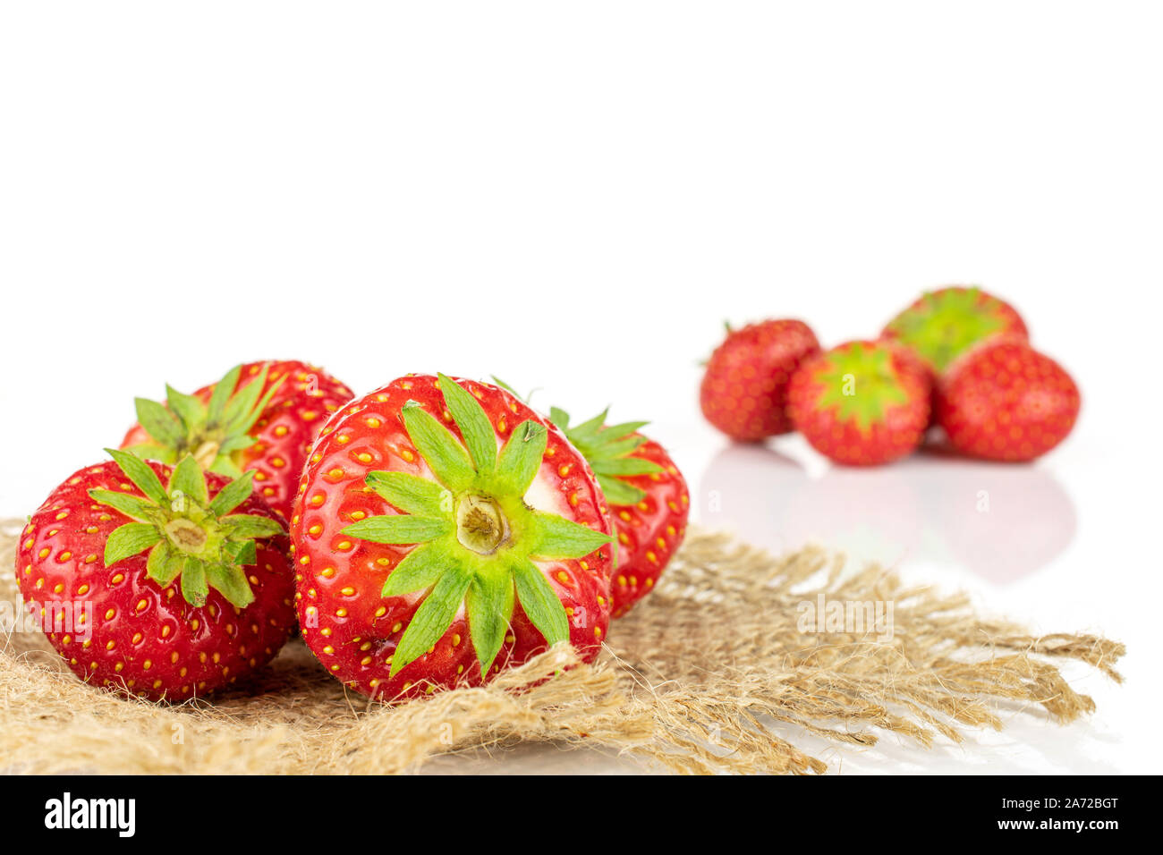 Lot of whole fresh red strawberry on natural sackcloth isolated on ...