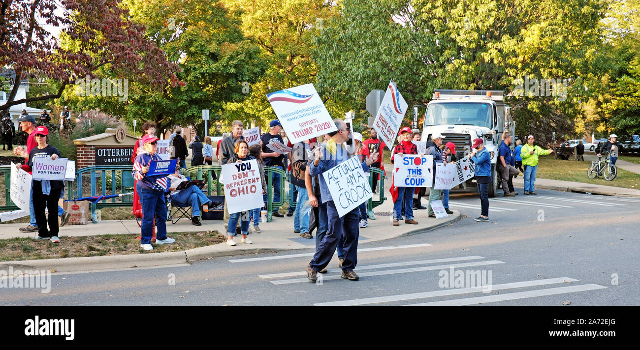 Trump supporters in Westerville, Ohio, USA, hold signs supporting the president while a protester walks by calling him a crook. Stock Photo
