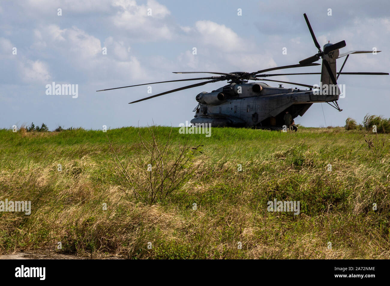 A CH-53E Super Stallion helicopter sits in a field during a rapid deployment exercise conducted by 1st Marine Aircraft Wing, III Marine Expeditionary Force, Okinawa, Japan, Oct. 25, 2019. As the only forward deployed MEF, III MEF is strategically postured to quickly and effectively respond to any crisis using austere, expeditionary bases and established airfields within the Indo-Pacific region. (U.S. Marine Corps photo by Lance Cpl. Tanner D. Lambert) Stock Photo