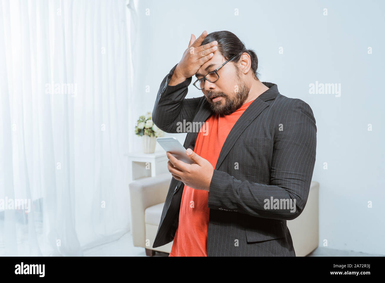 disapointed businessman receiving text message on his smartphone Stock Photo