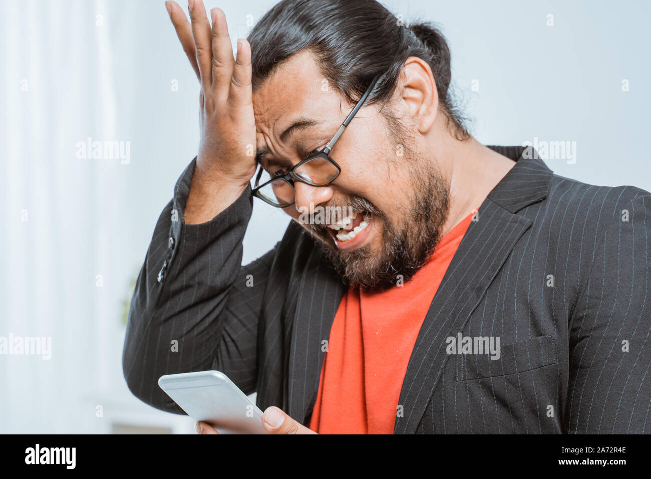stress businessman holding his phone at the office Stock Photo